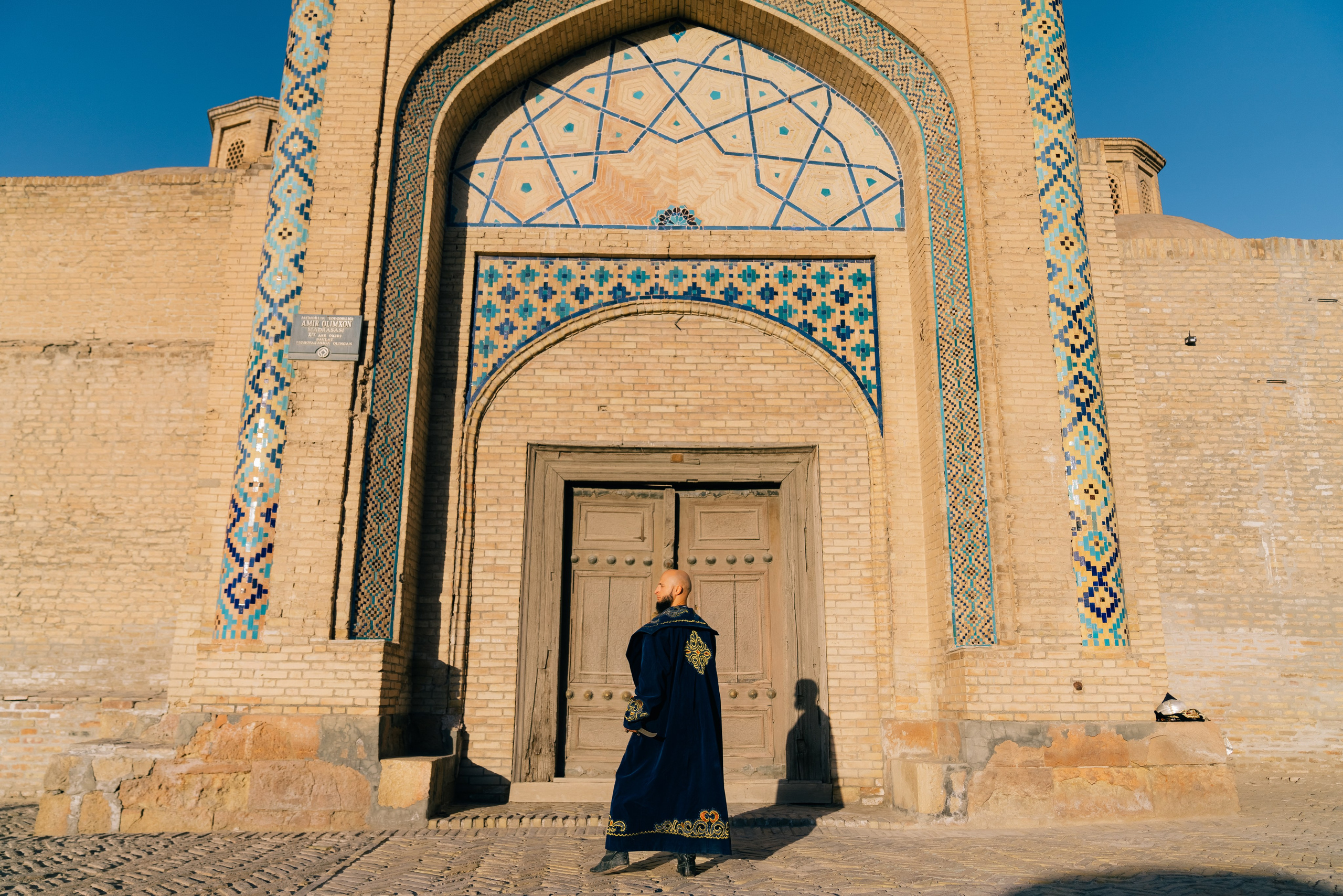 Men's photoshoot in ethnic clothing near the walls of Bukhara