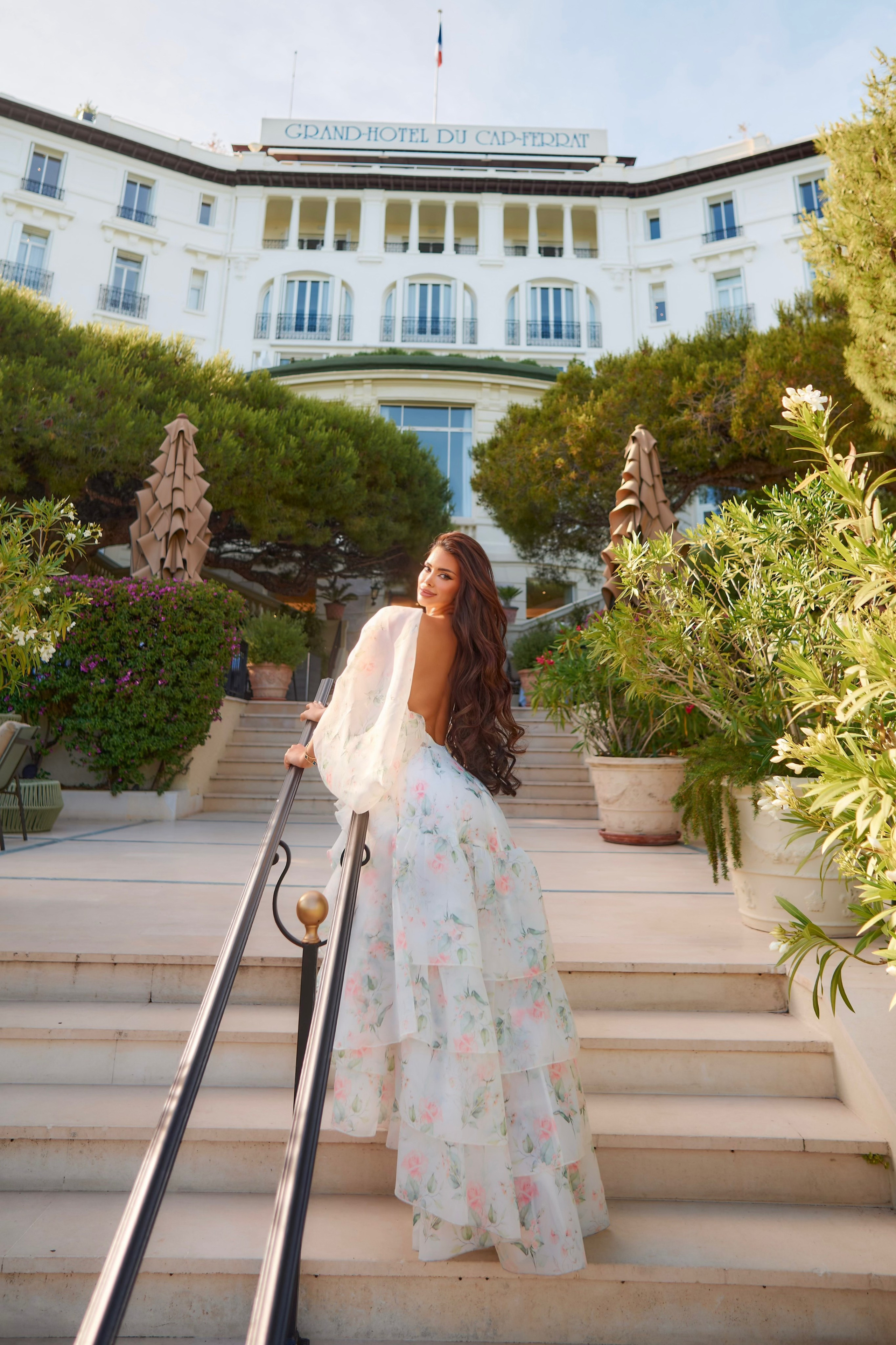 Elegant woman in summer dress captured on luxury hotel grounds Saint-Jean-Cap-Ferrat