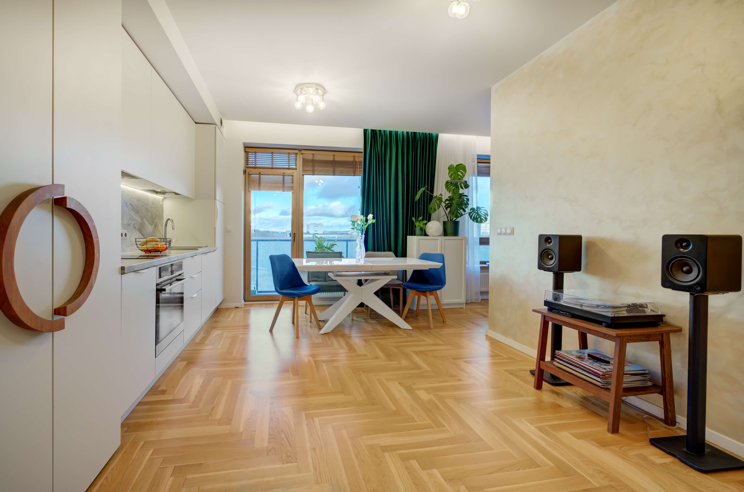 Atvira erdvė su balkonu: medinės durys, Sonos garso sistema ir švarus minimalizmas