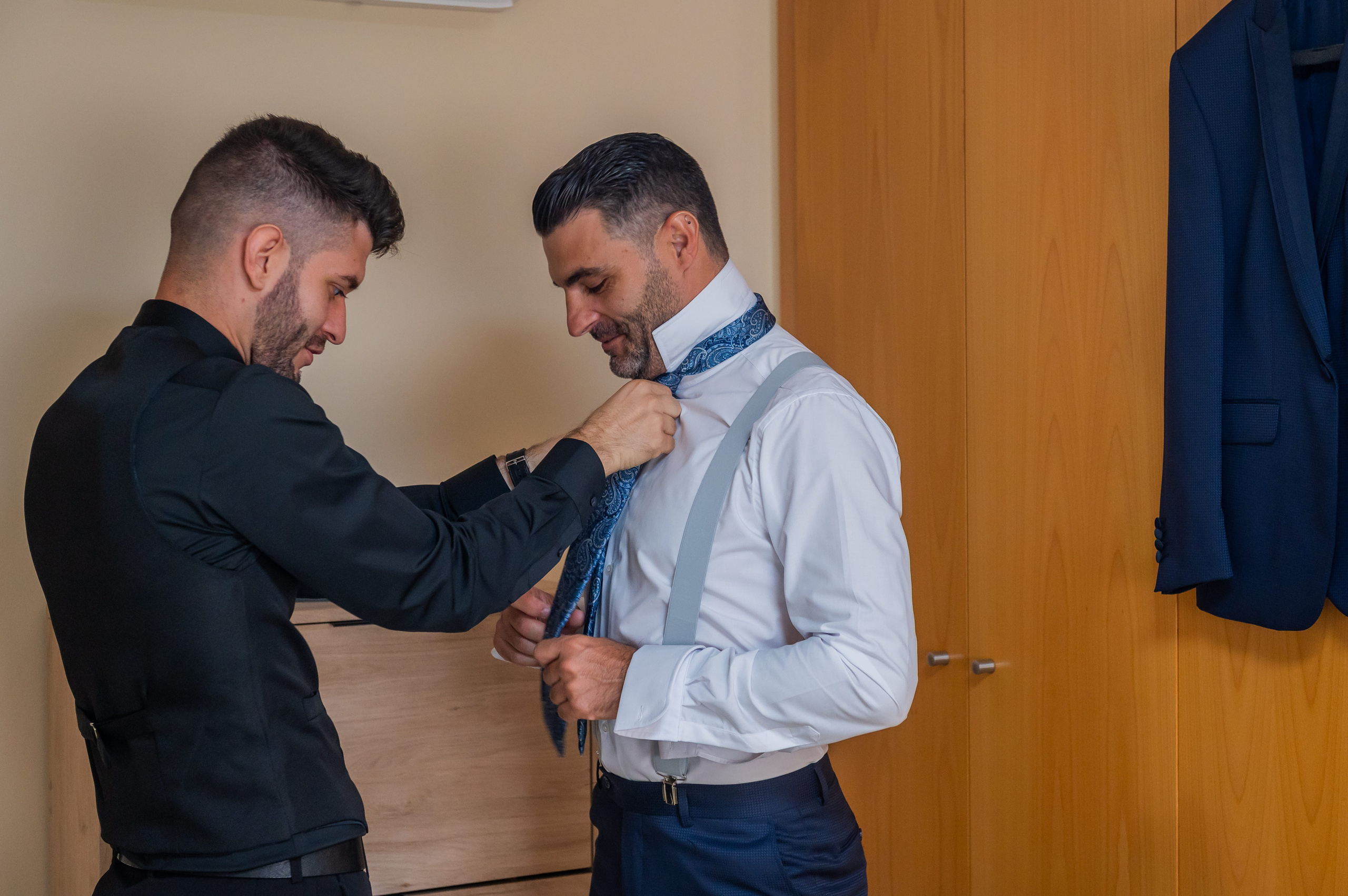 Amigo ayudando al novio con la corbata