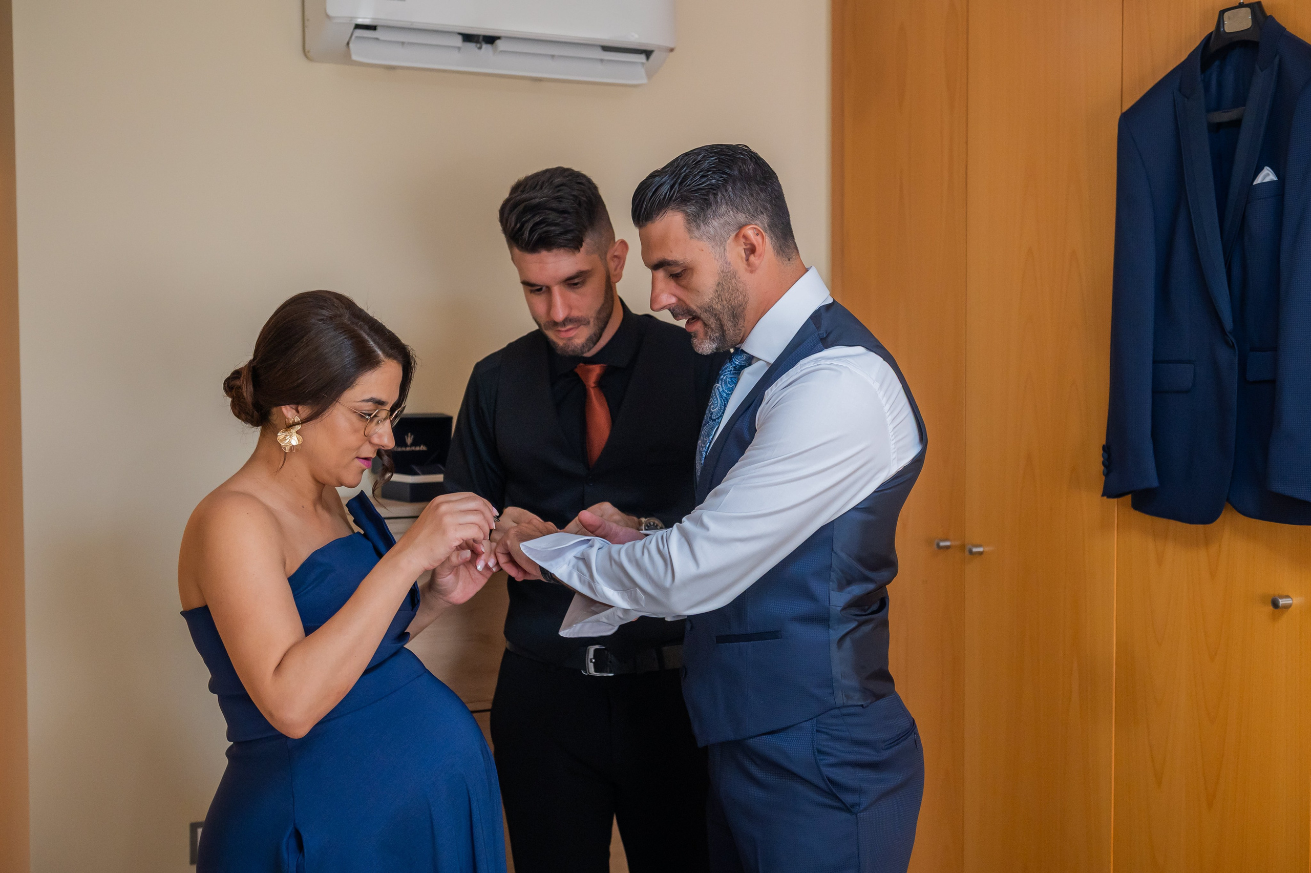 Hermanos ayudando al novio a vestirse