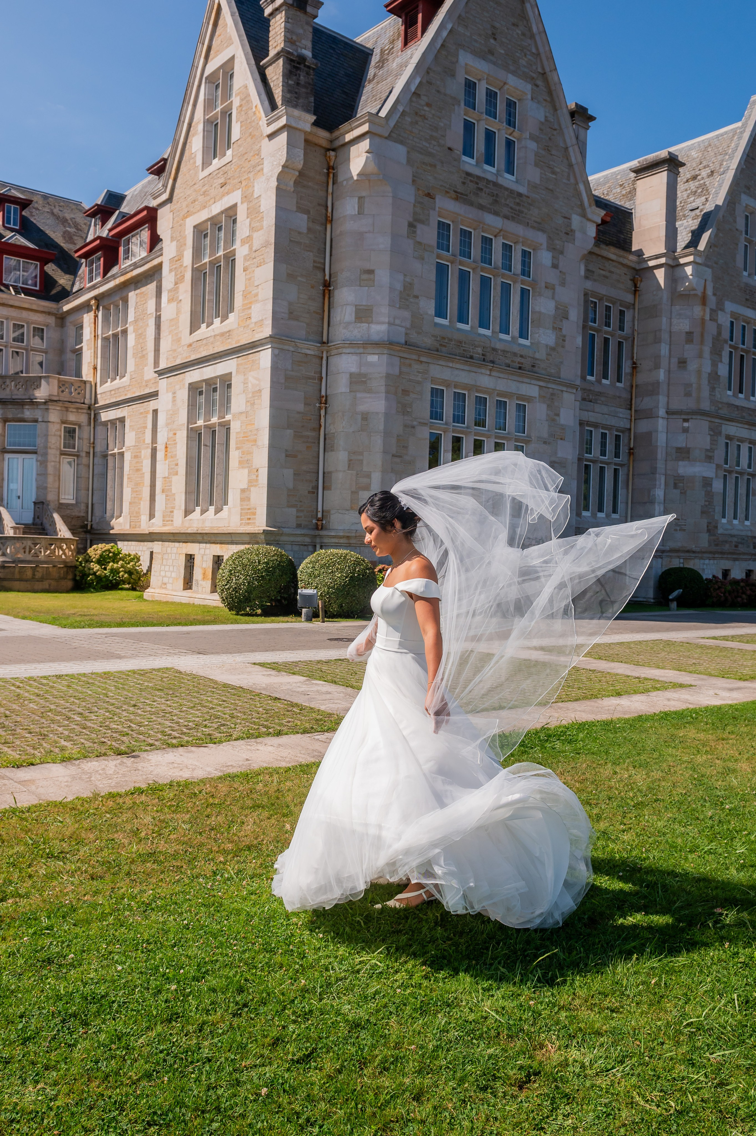 Novia girando con el velo al viento frente al palacio