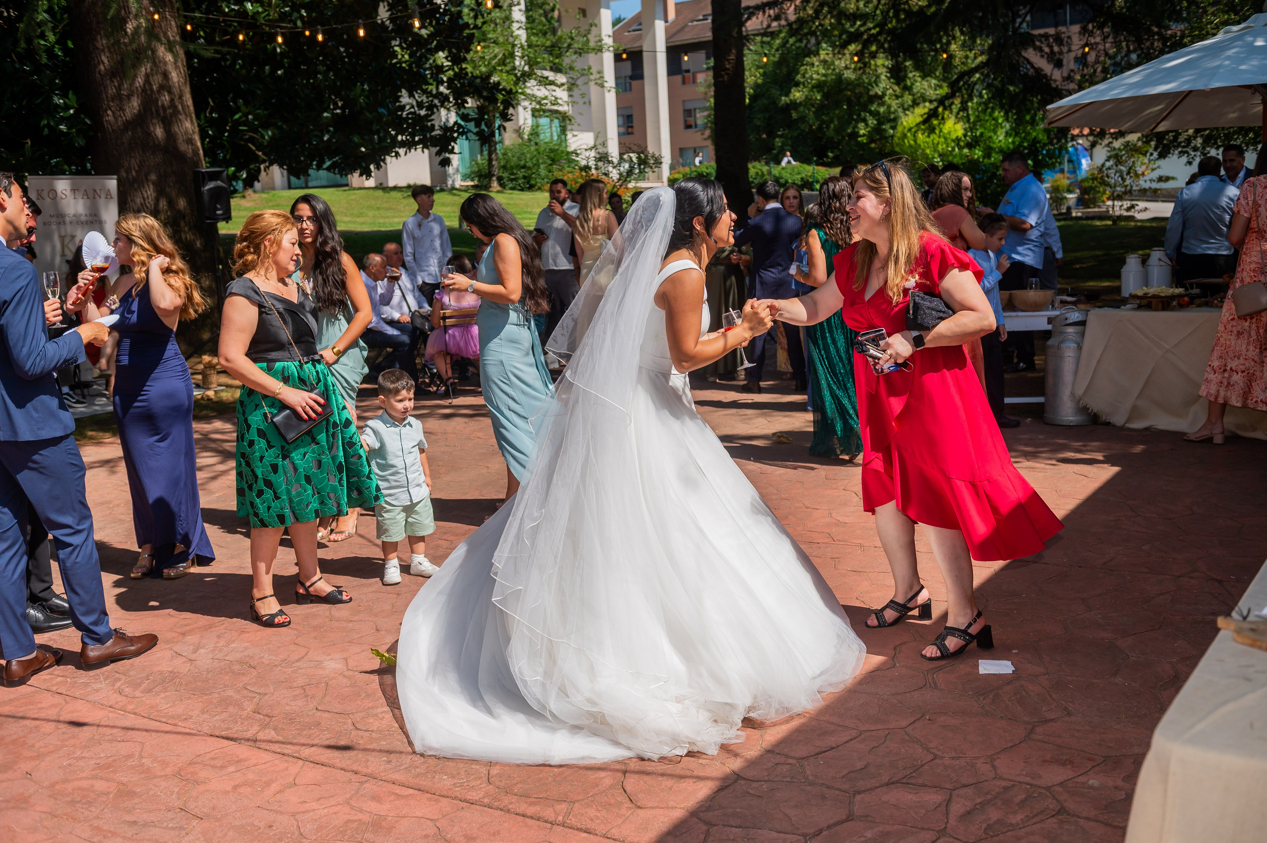 Novios bailando con los invitados en el cóctel al aire libre