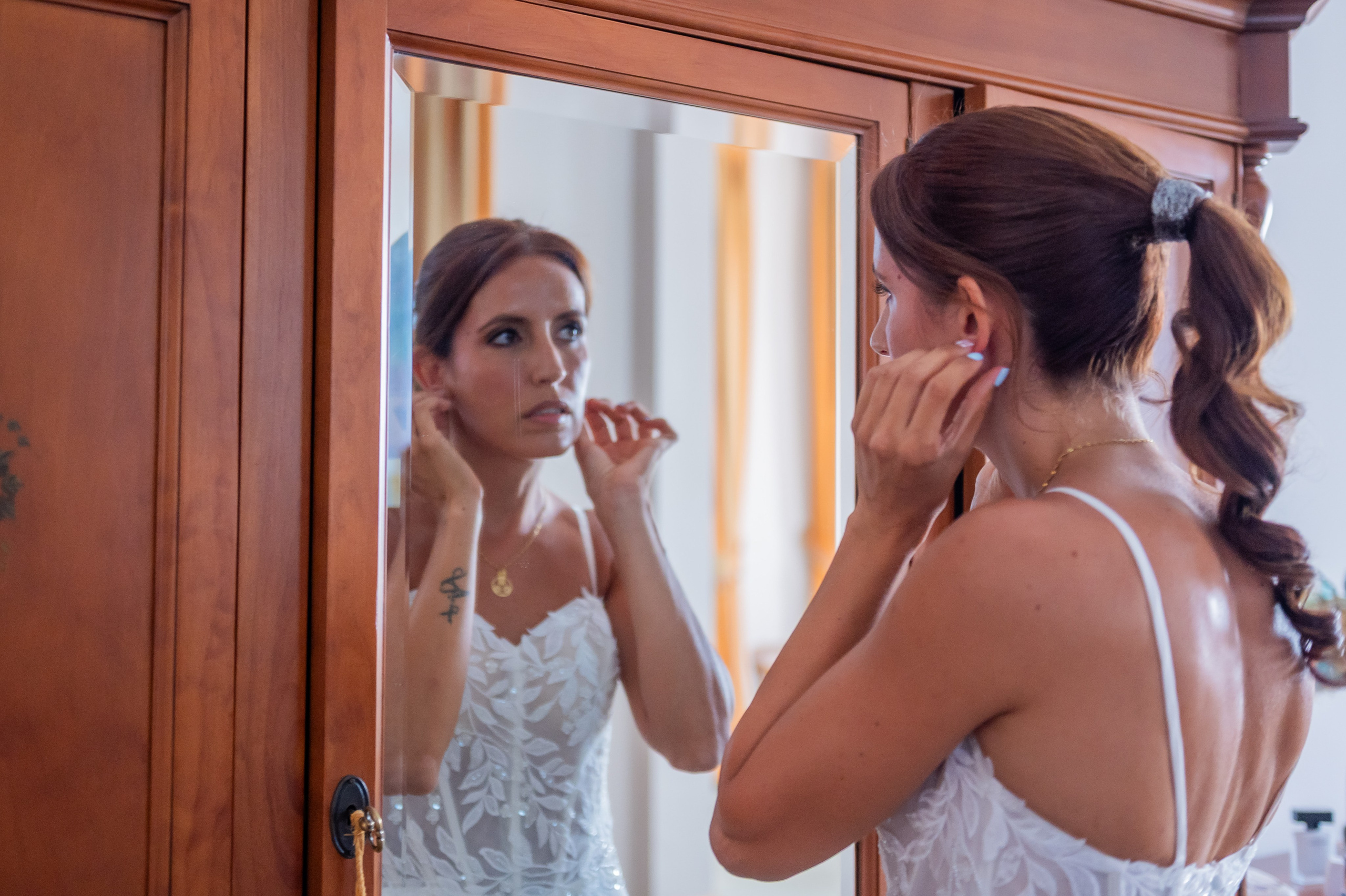 Sara poniéndose los pendientes frente al espejo