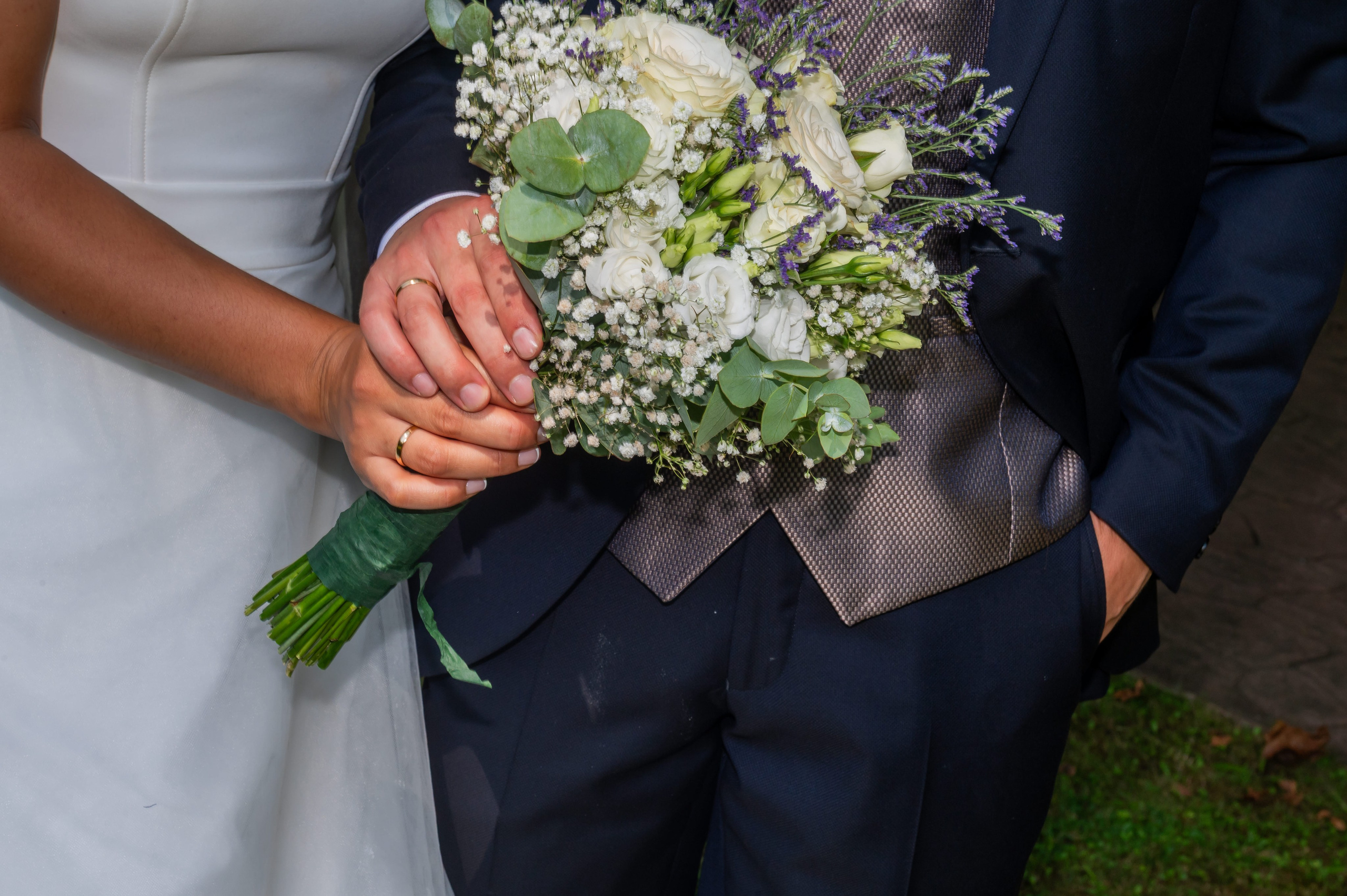 Detalle del ramo de novia y la mano del novio