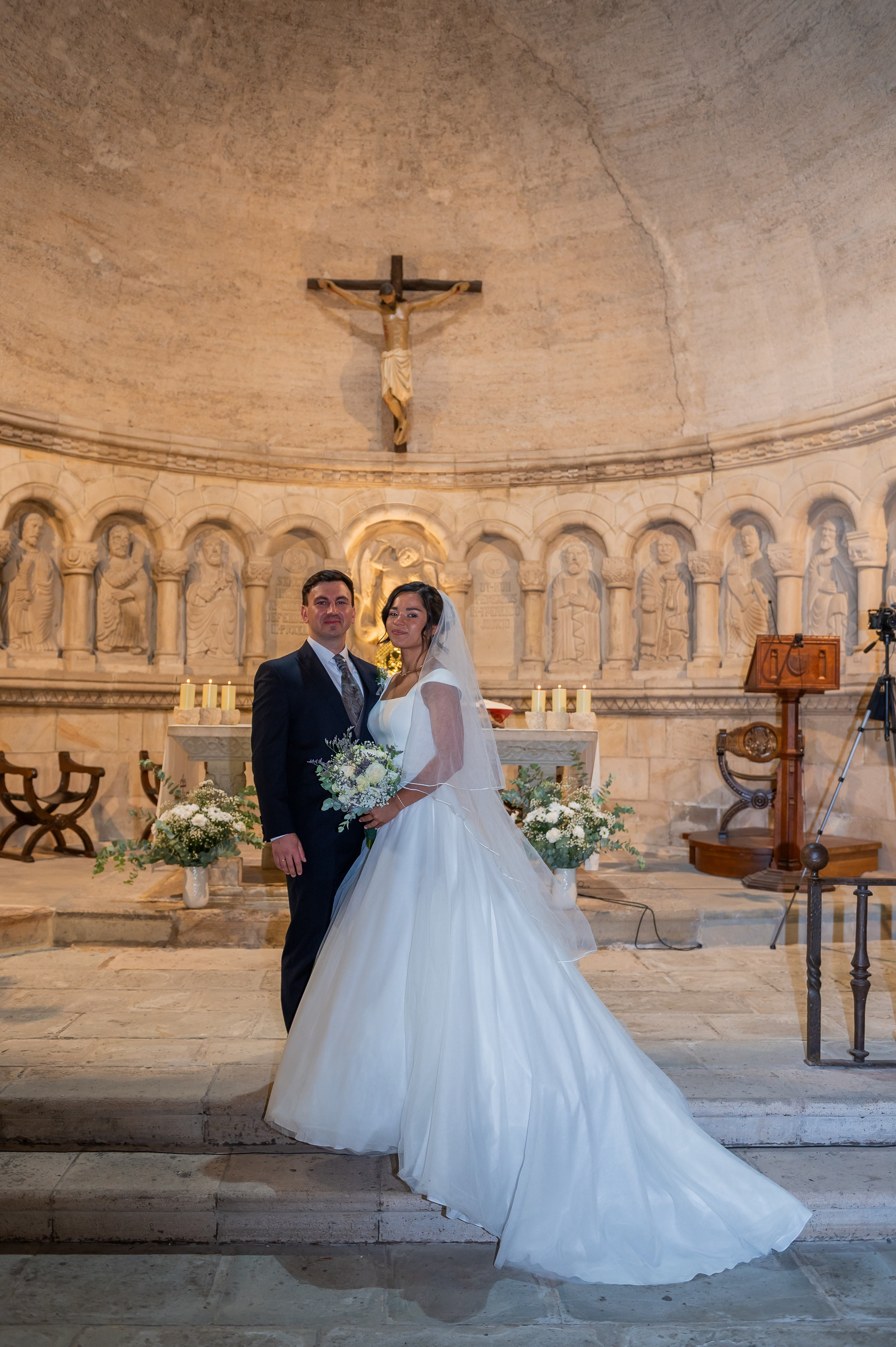Novios en el altar bajo la cruz de la iglesia
