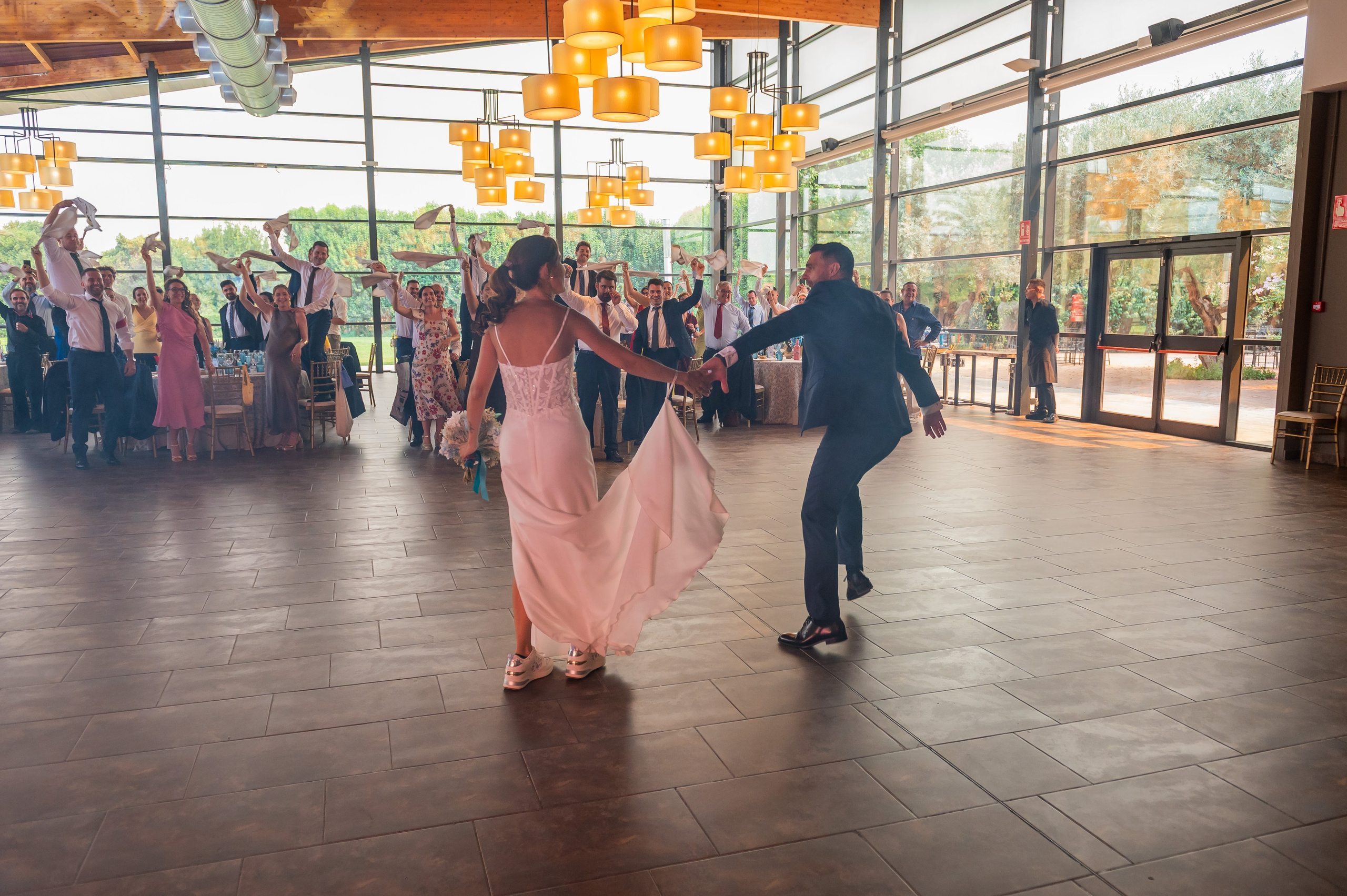 Novios bailando ante los invitados en el banquete