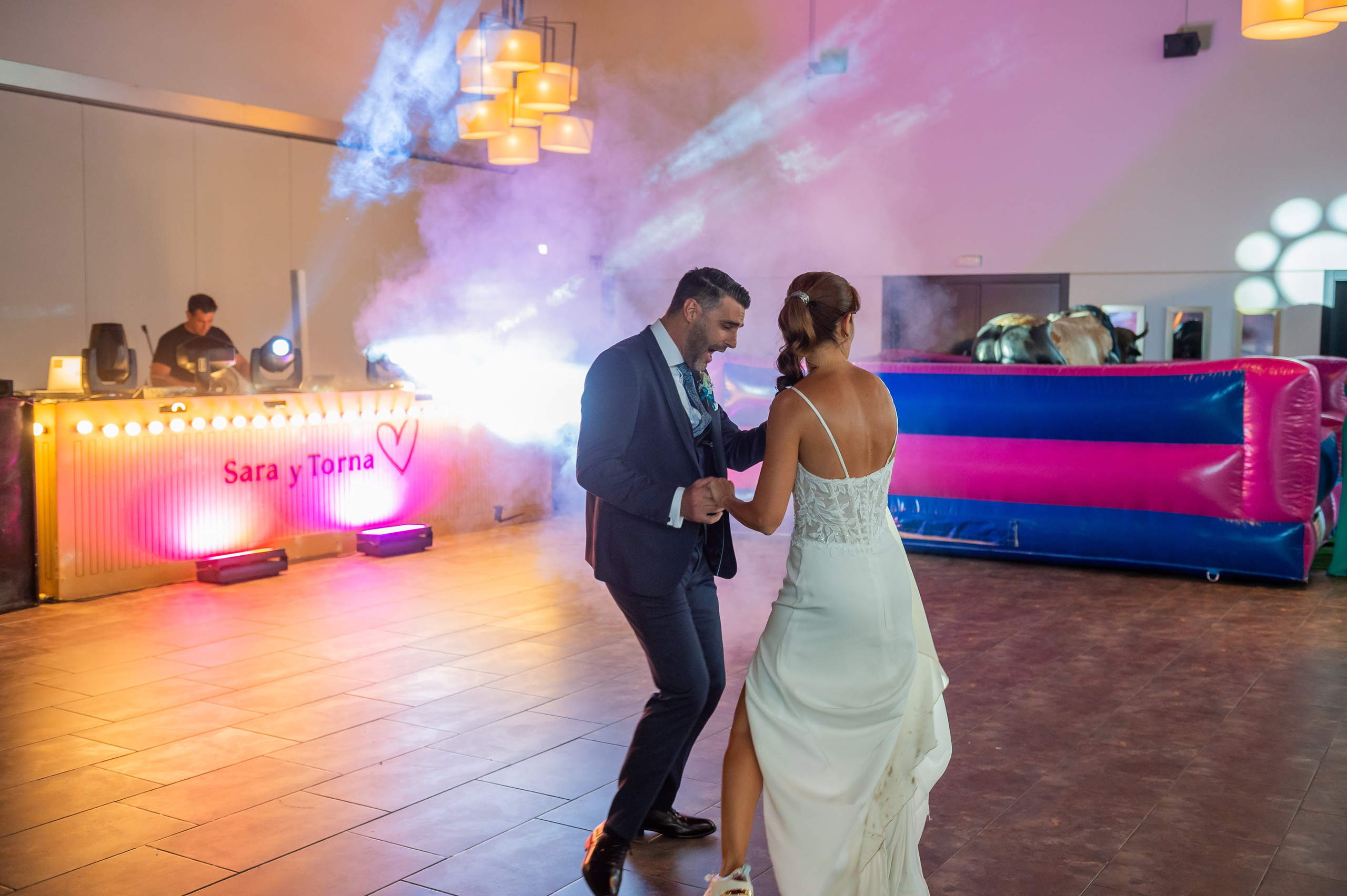 Novios bailando en la pista iluminada