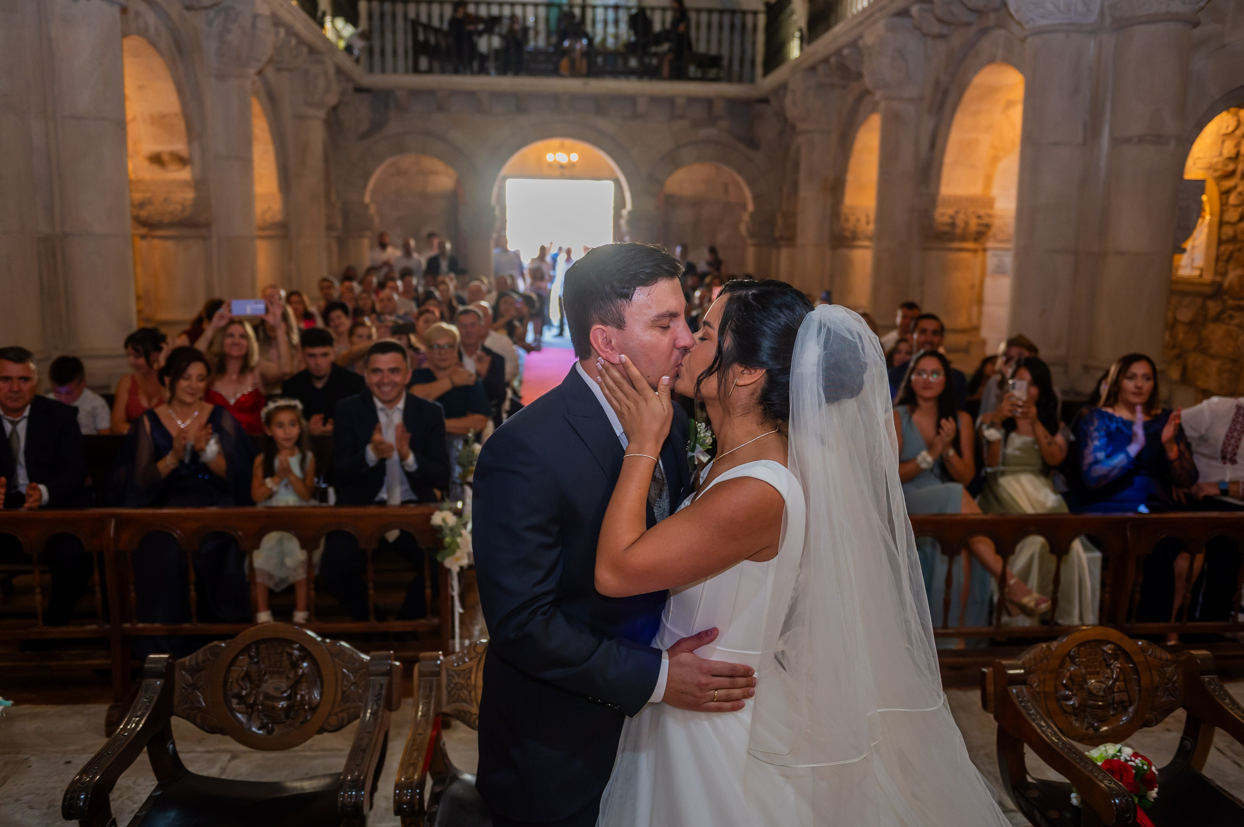 Beso de los novios ante los invitados en la iglesia