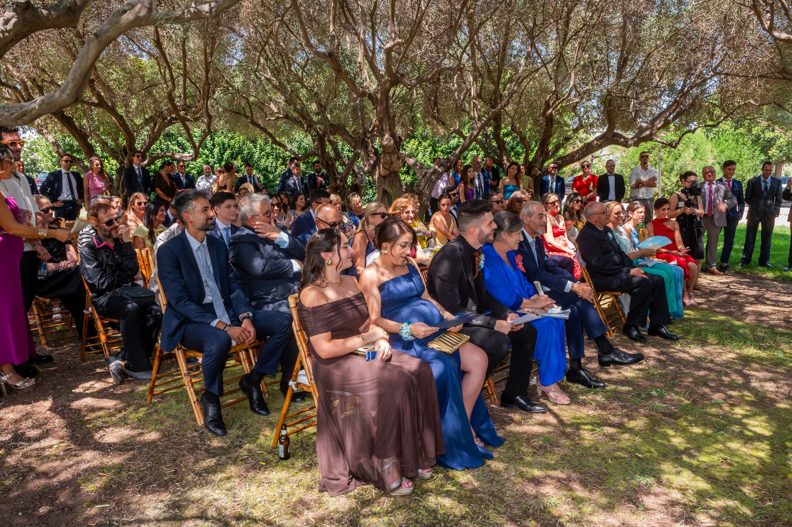 Invitados sentados en el jardín durante la ceremonia