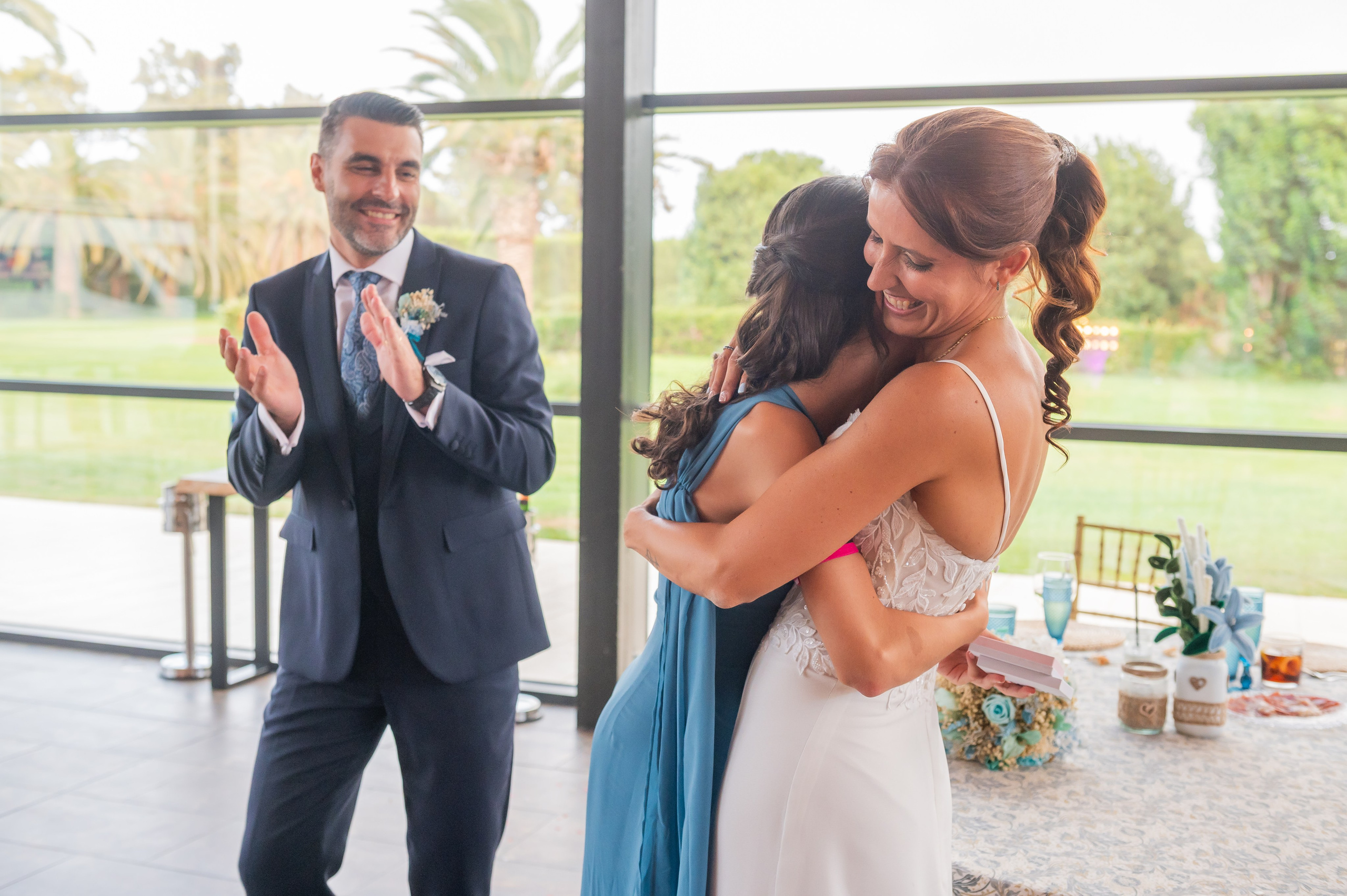 Sara abrazando a una invitada vestida de azul