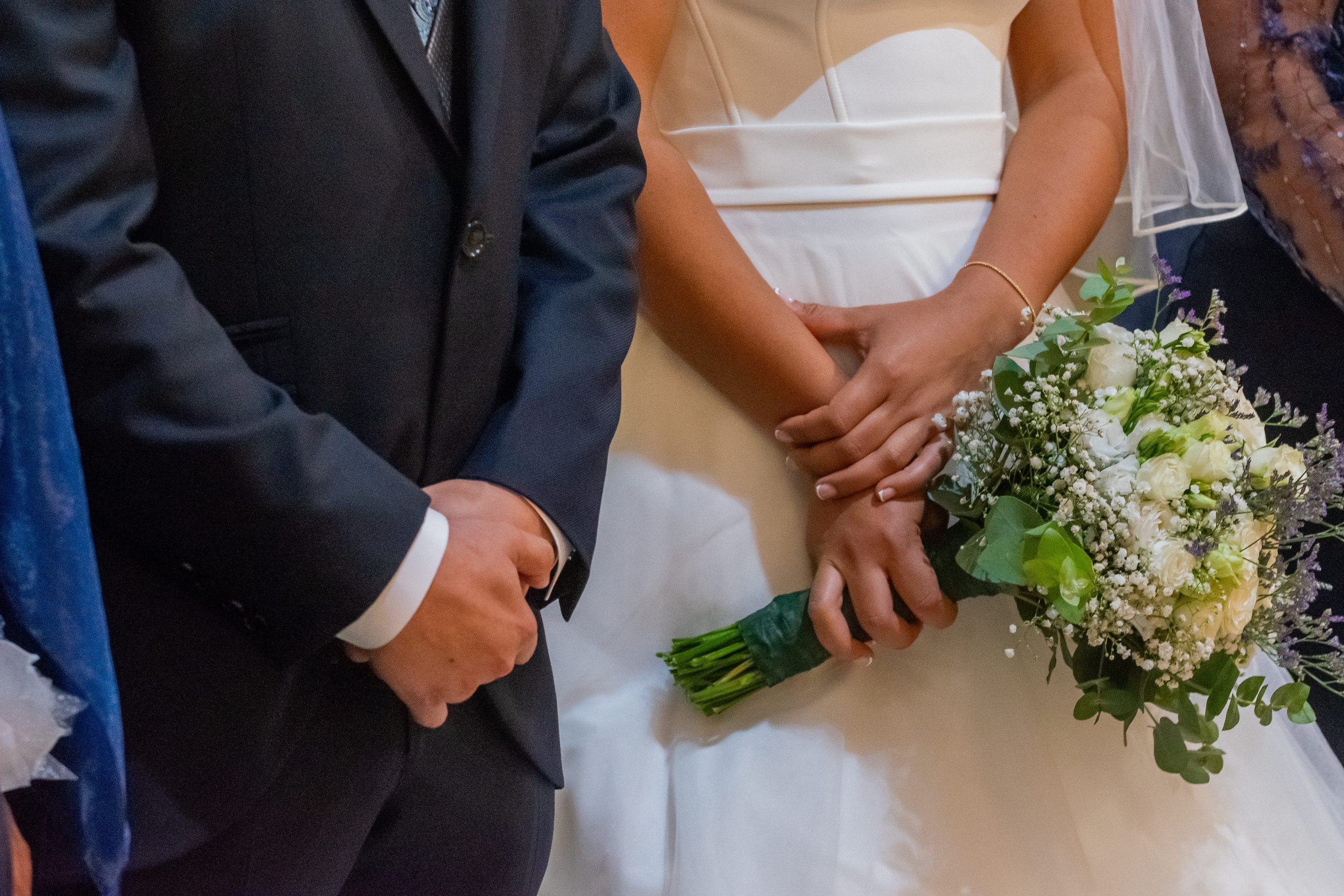Detalle del ramo de novia y las manos de los novios