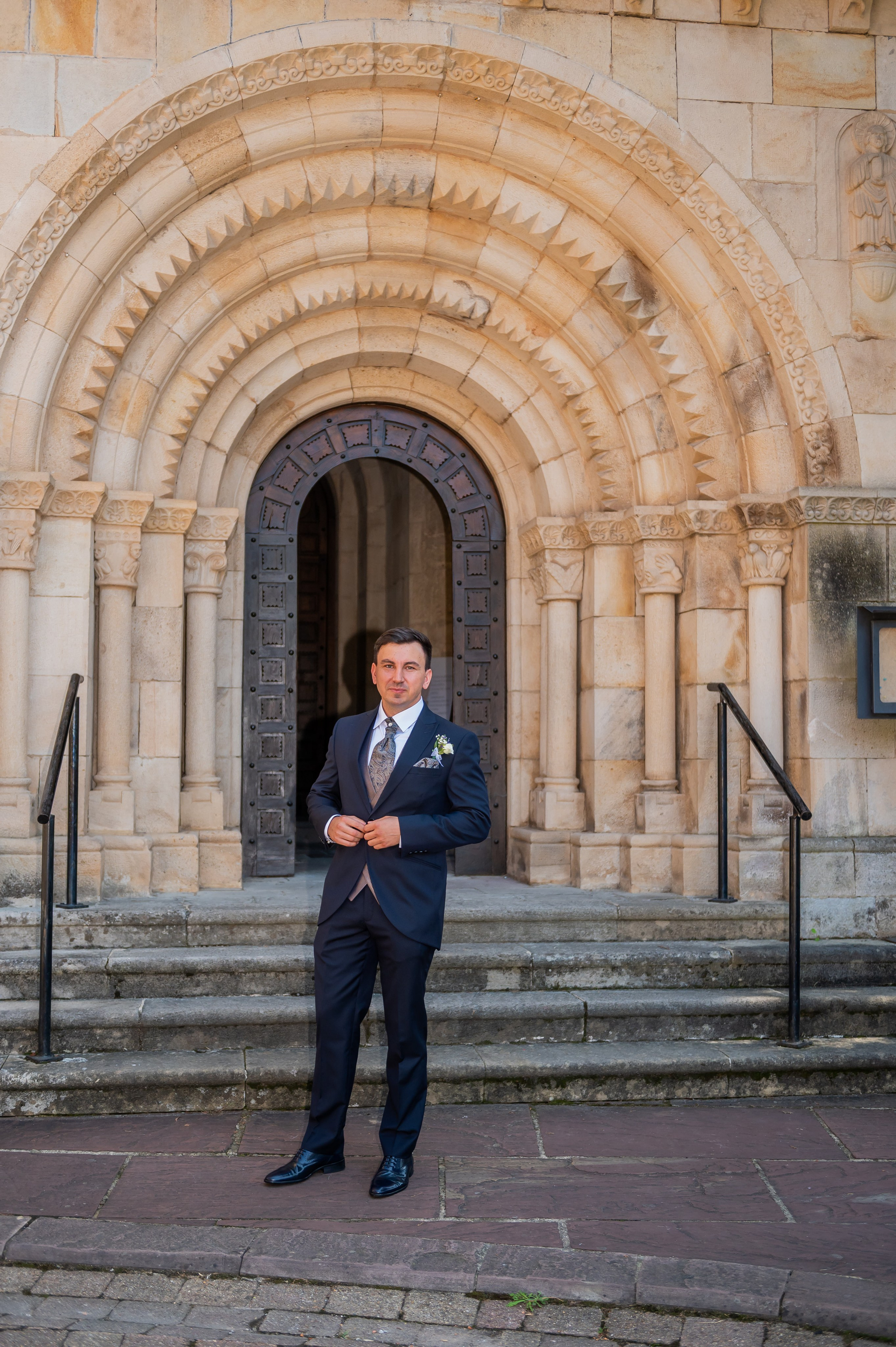 Alex esperando ante la portada románica de la iglesia