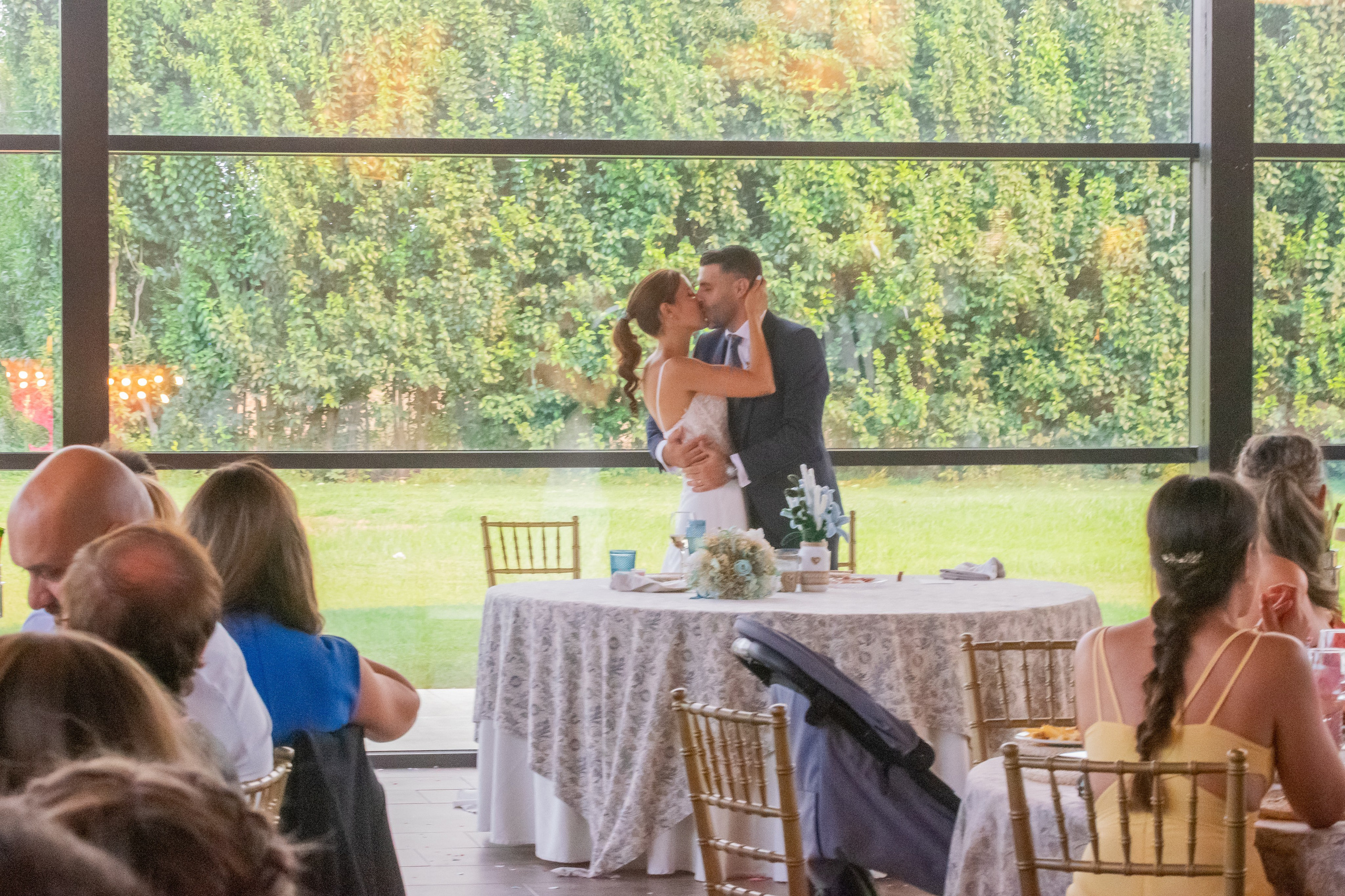 Beso de los novios junto a la tarta