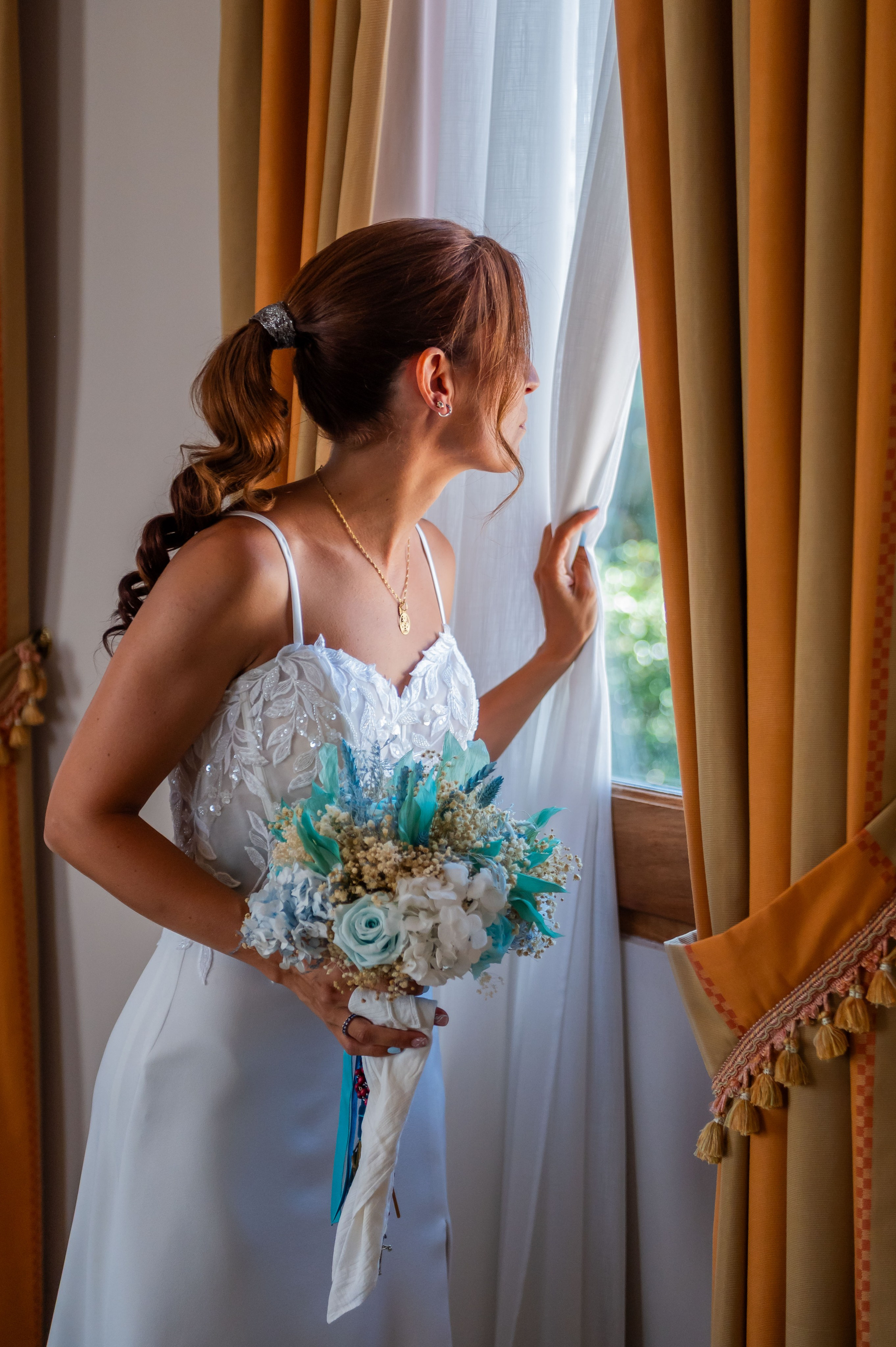 Sara con su ramo junto a la ventana · fotógrafo de bodas en Castellón