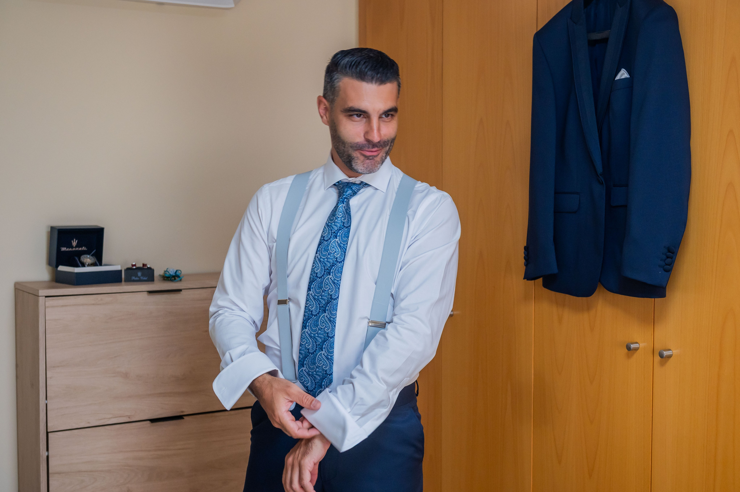 Novio con camisa y corbata azul en la habitación