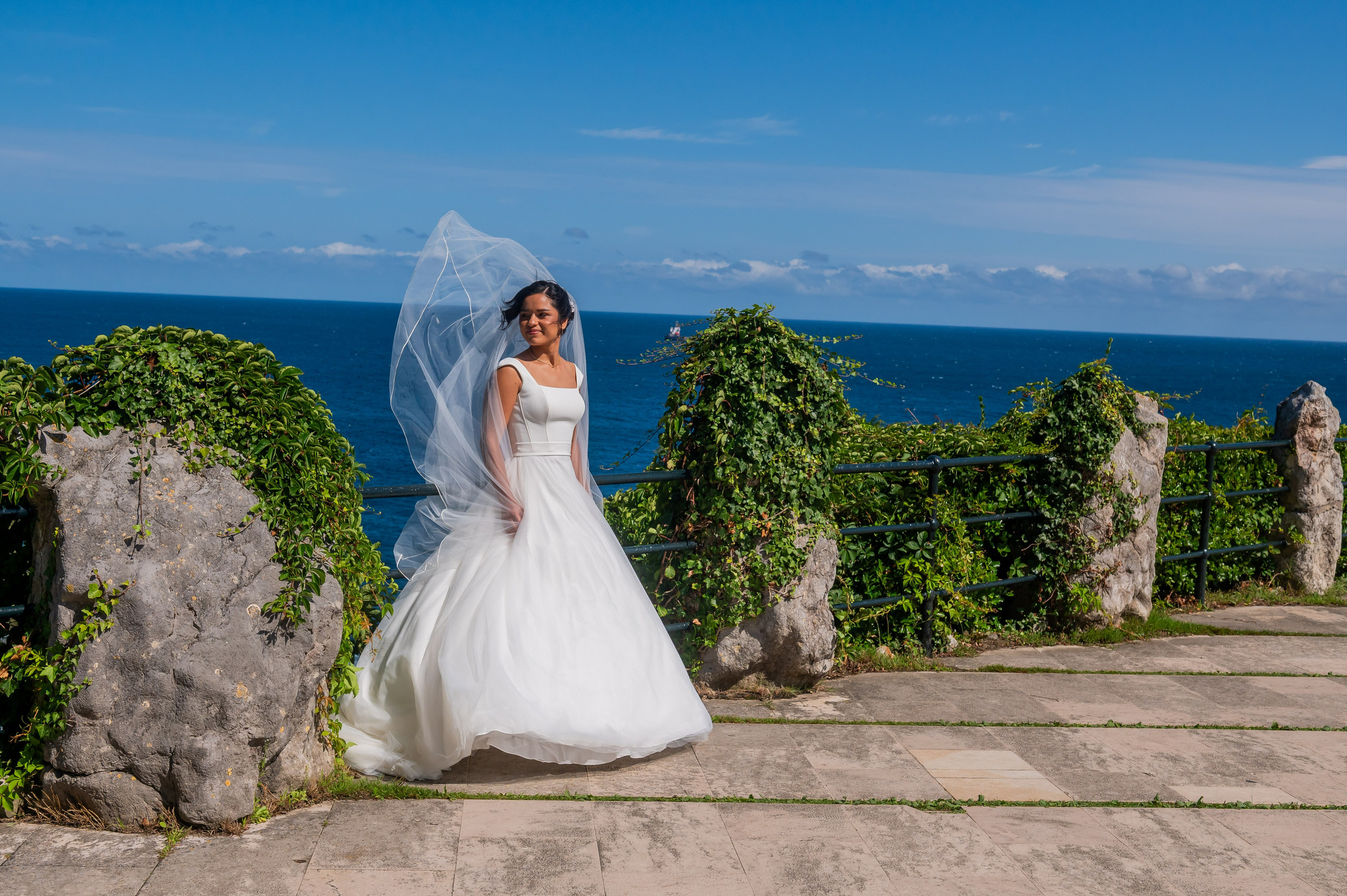 Novia junto al mar Cantábrico con el velo al viento
