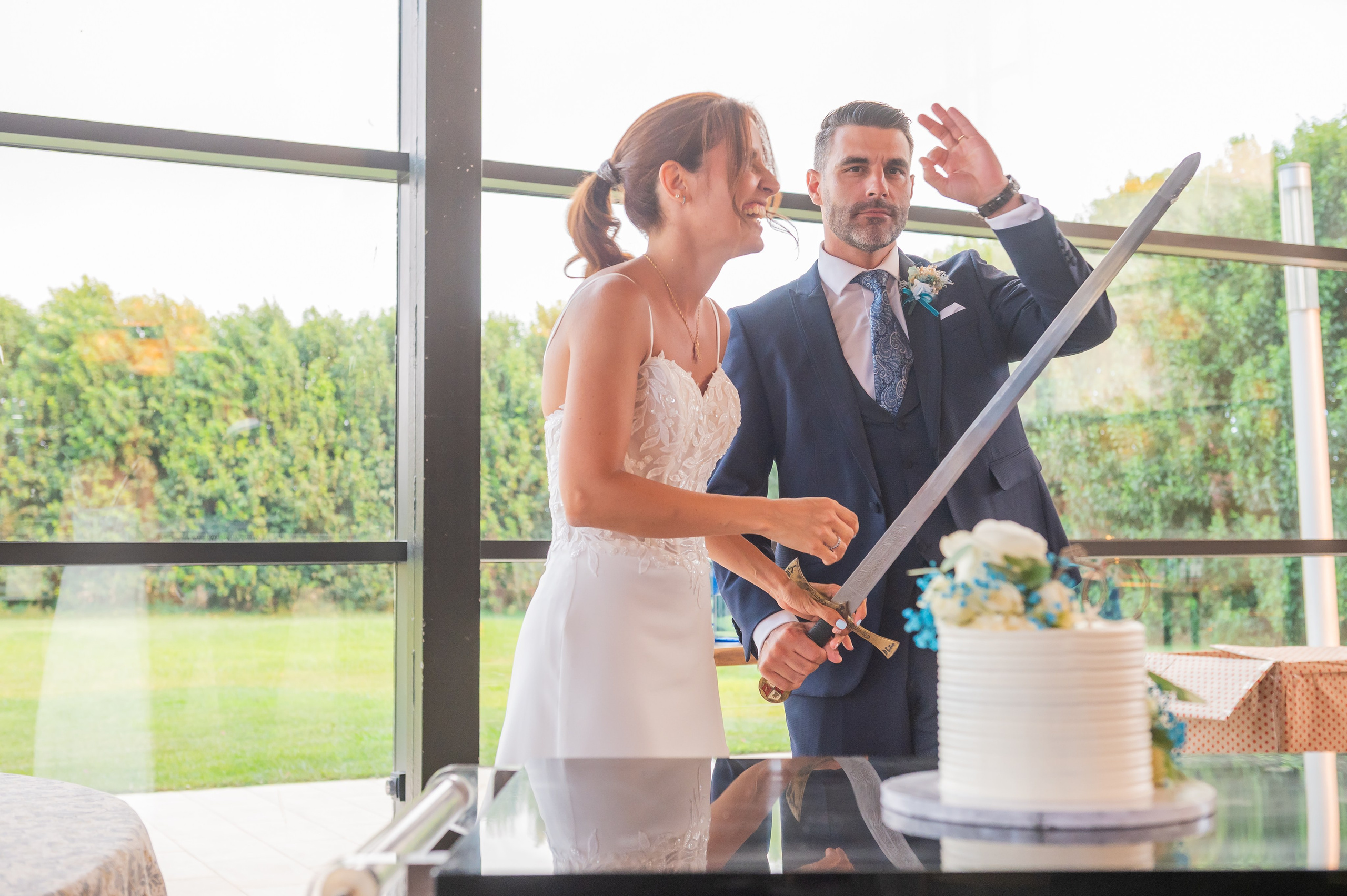 Novios cortando la tarta con una espada