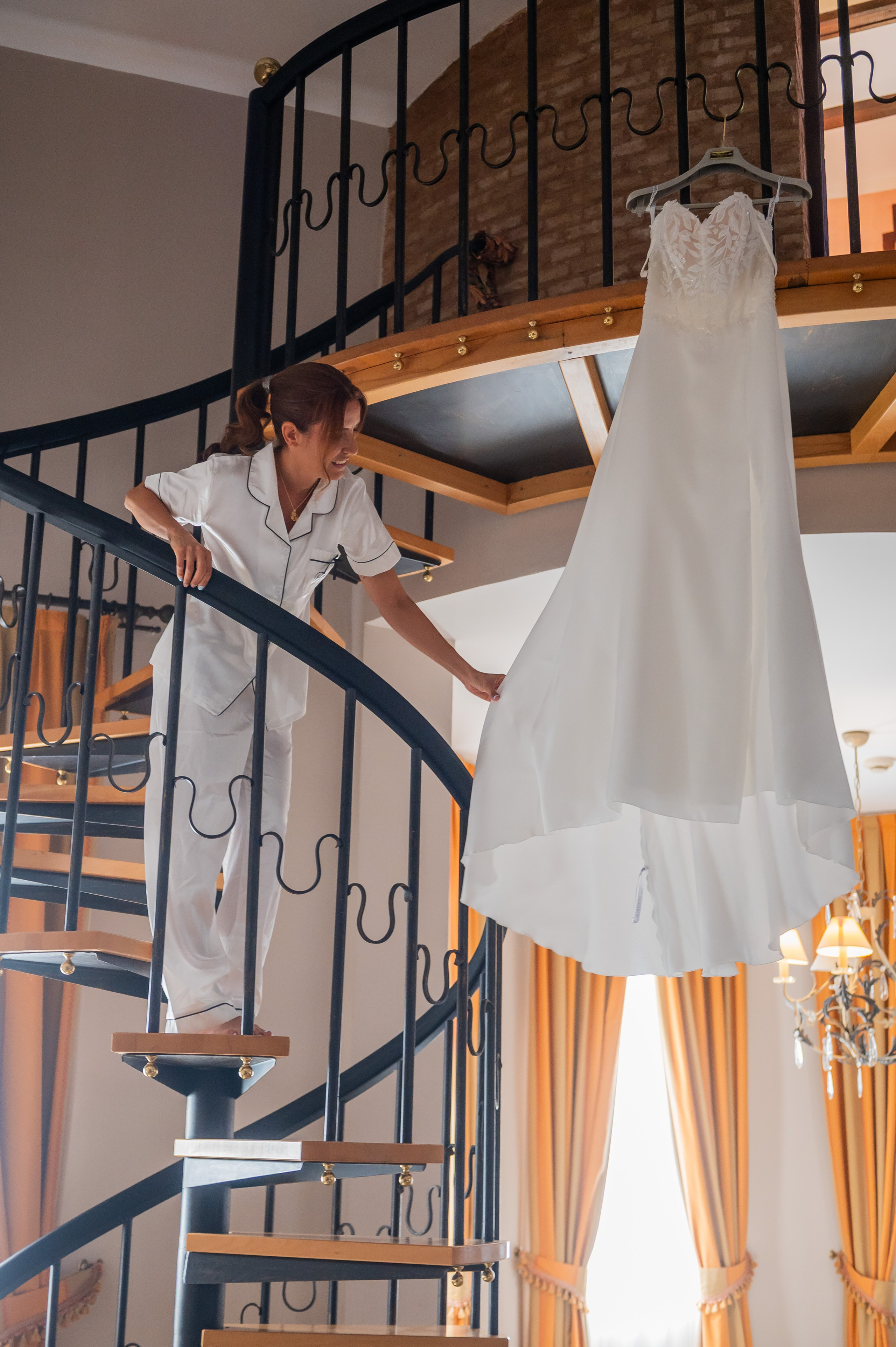 Vestido de novia colgado en la escalera de la torre