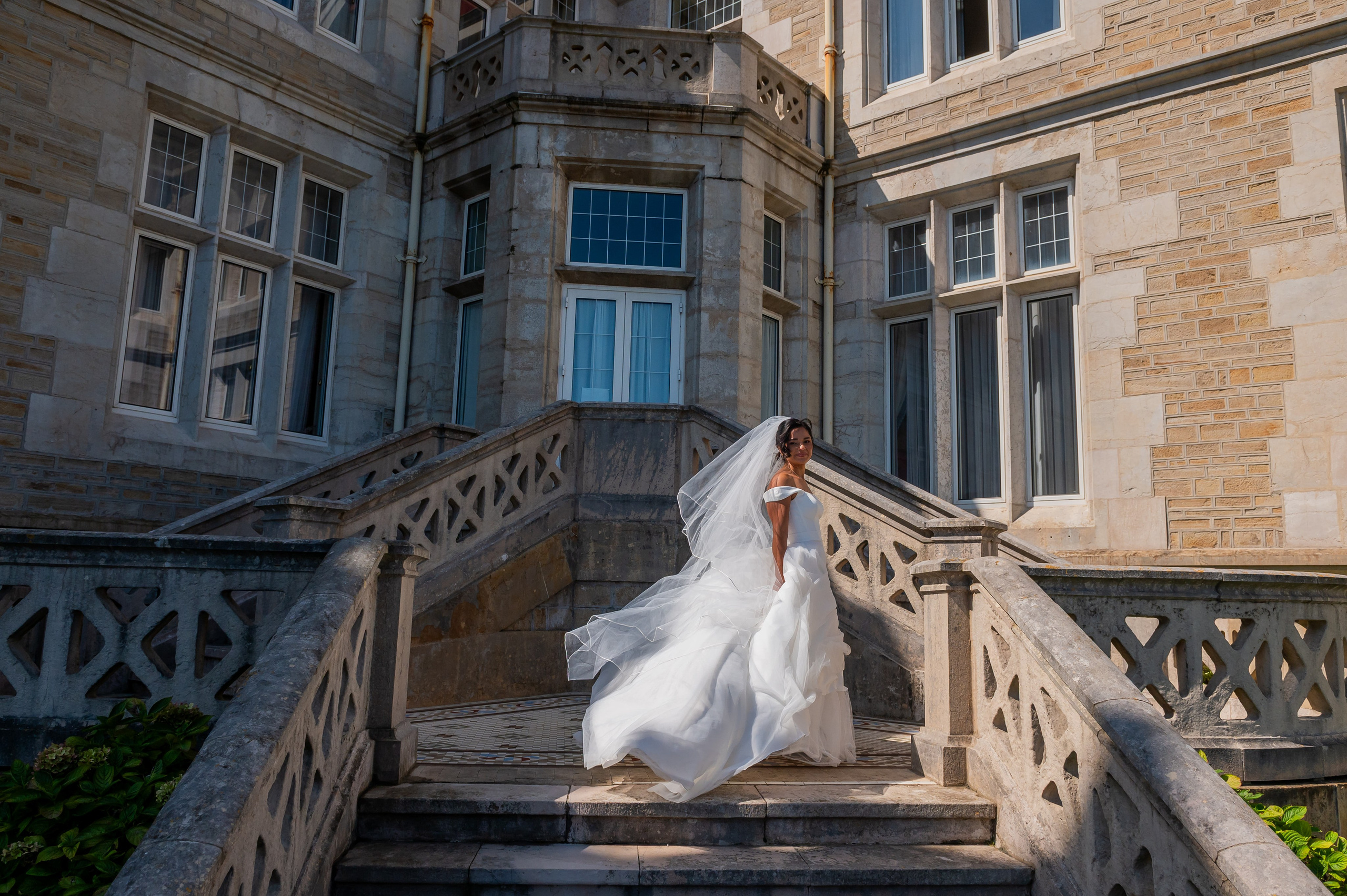 Novia bajando la escalinata del palacio con el velo al viento