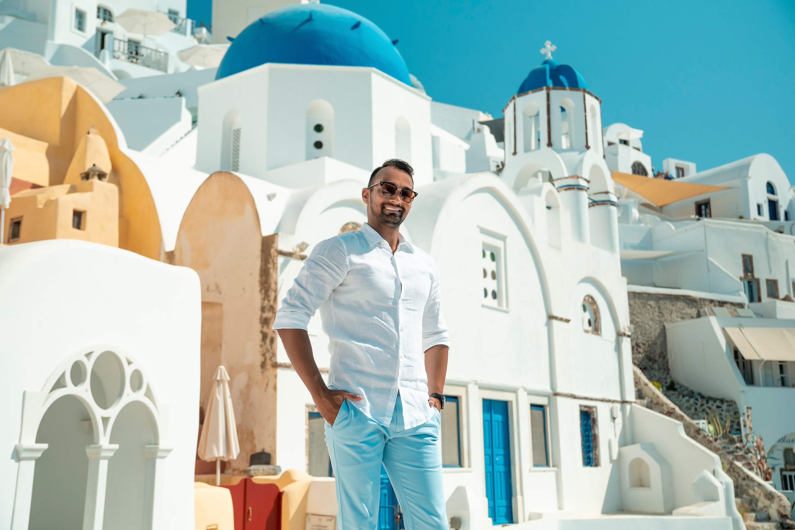 “Stylish man portrait in Santorini, Greece – professional photoshoot with iconic white and blue background.”