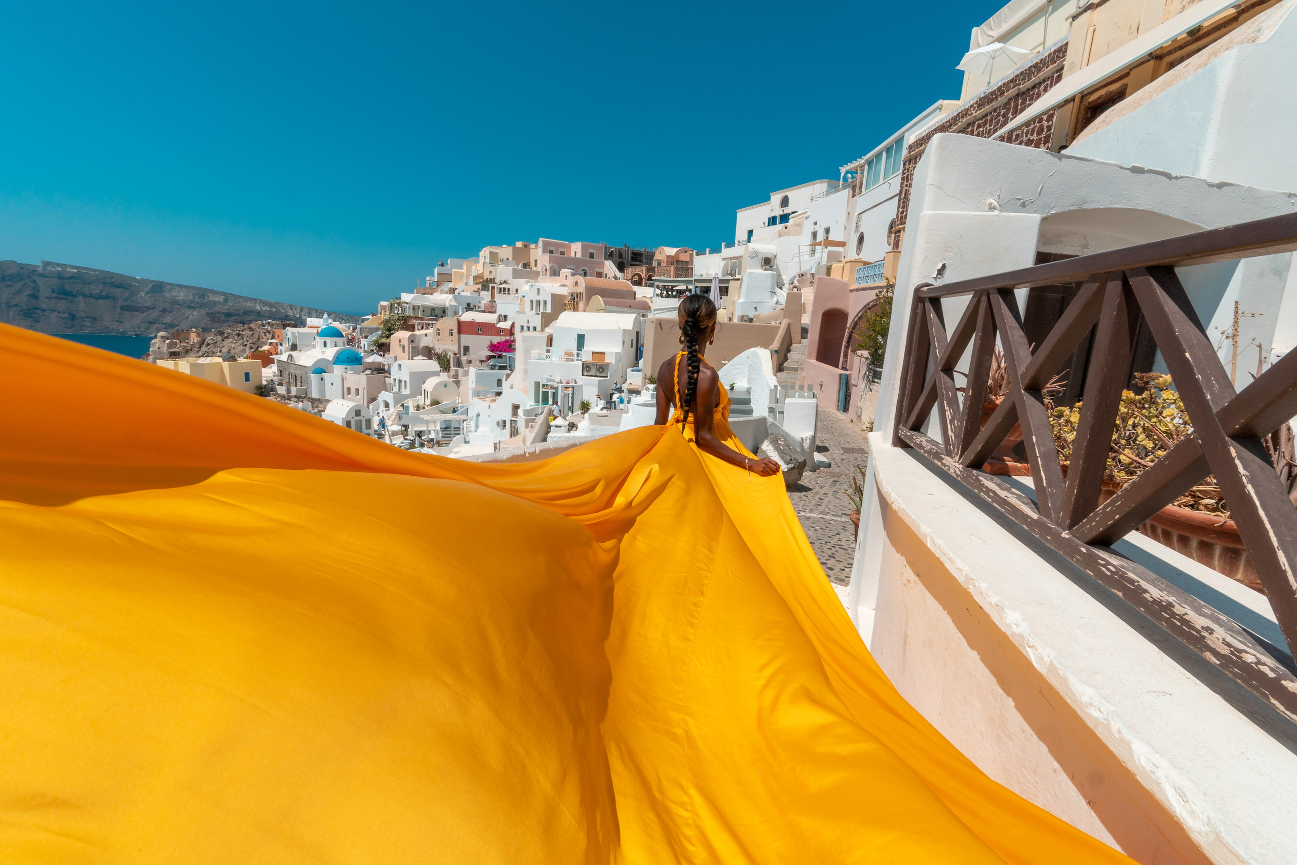 Robe Volante Jaune – Location pour Séance Photo à Santorin – Élégance et Moments Inoubliables. Photographe vidéaste à Santorin|Séances photos de Robe volante Santorin|