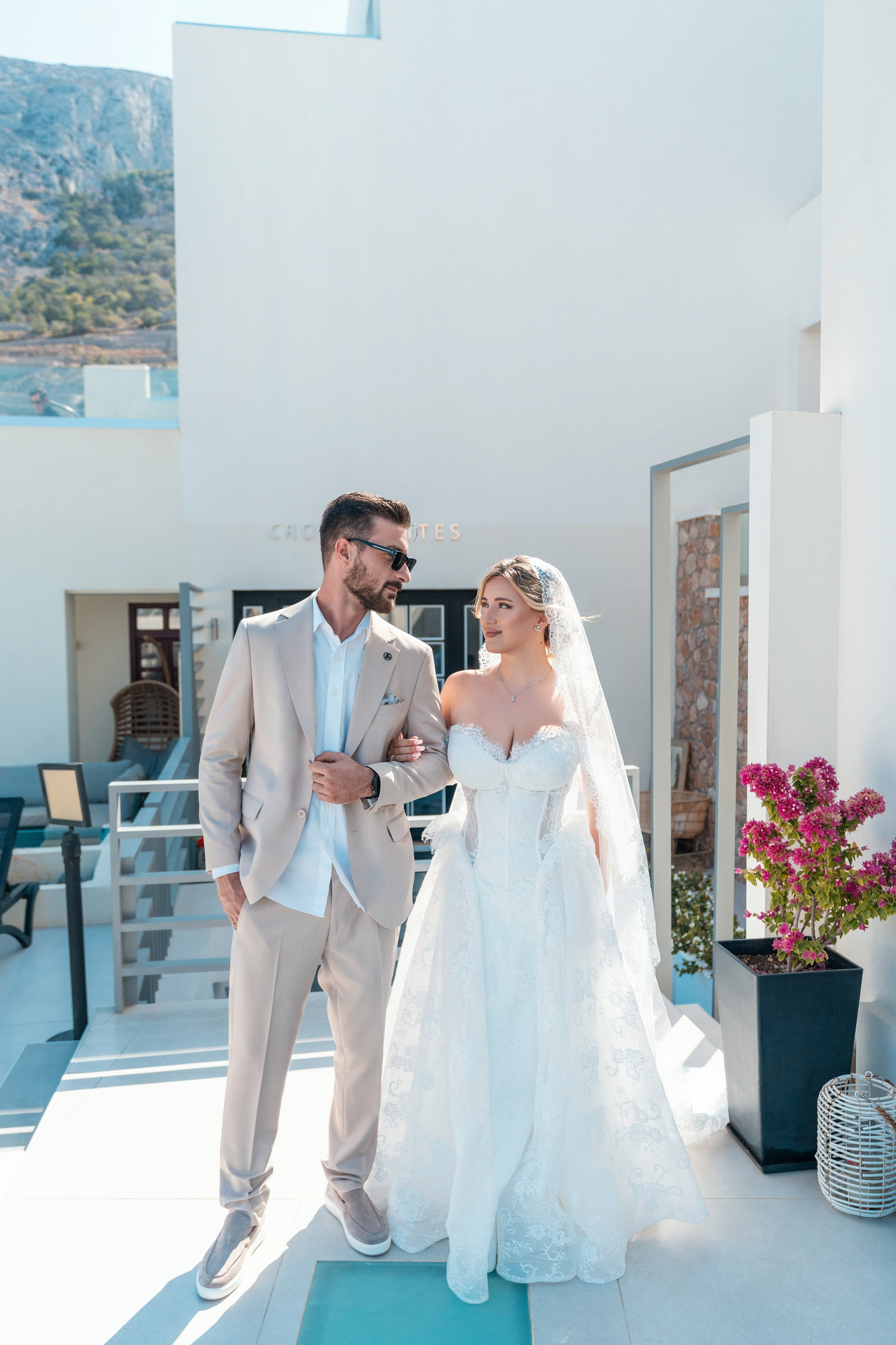 Groom kissing bride near blue dome churchAlt text: Bride and groom kiss by iconic blue dome in Santorini – authentic wedding moments captured by Alex SokoloveCaption/Title: Pure joy under Santorini's famous blue domes – a stolen kiss in paradise