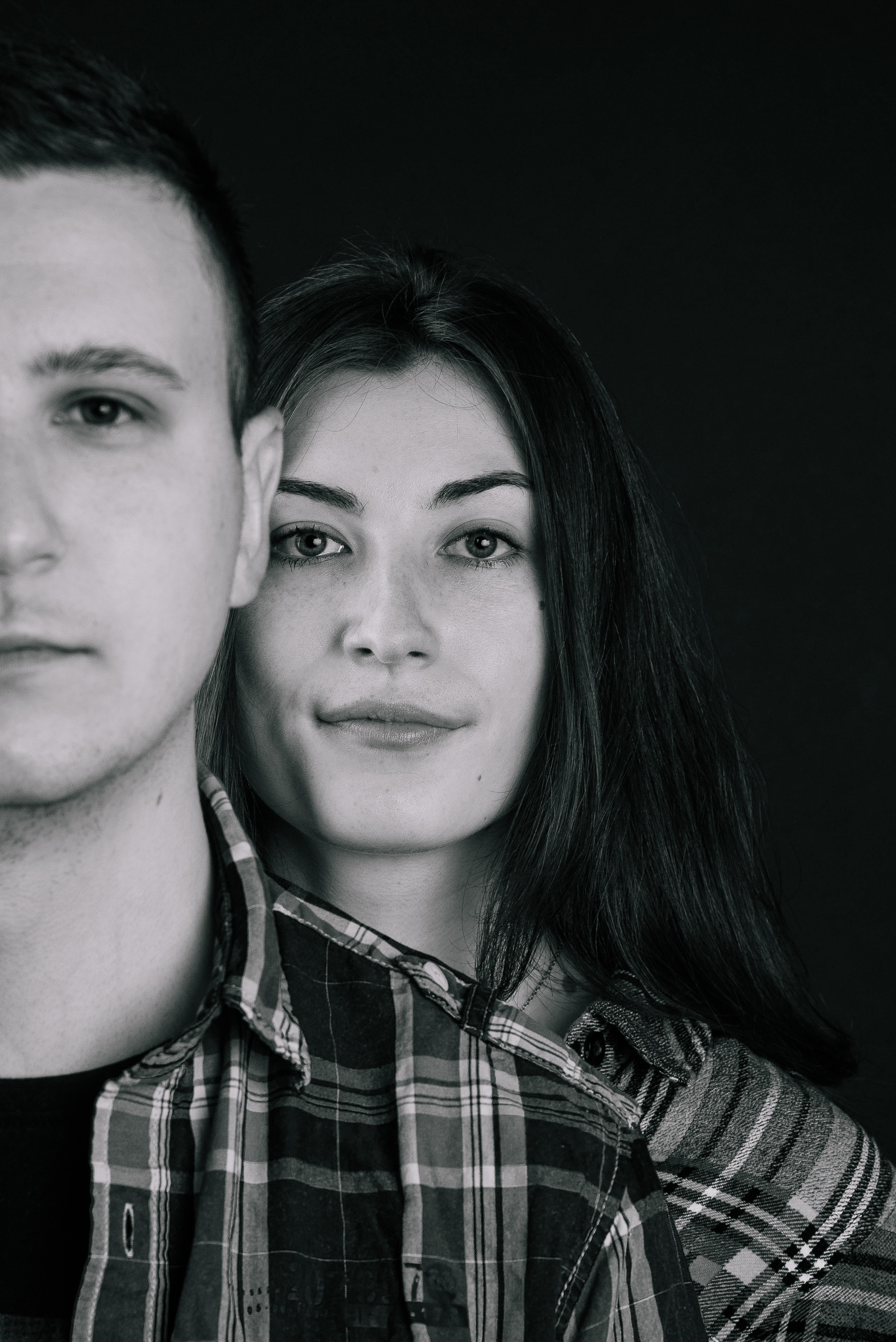 Nahaufnahme zweier Gesichter vor dunklem Hintergrund, kreatives und minimalistisches Porträt.