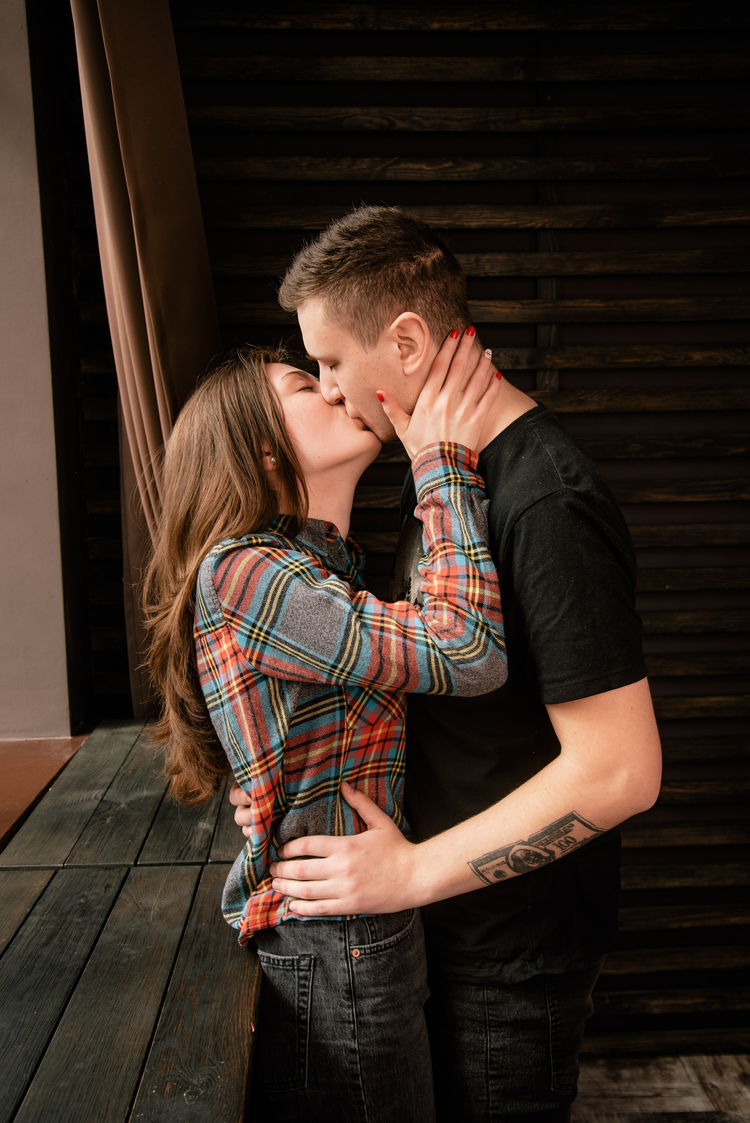 Zwei Personen stehen nah beieinander am Fenster, natürlicher Lichteinfall und warme Stimmung.