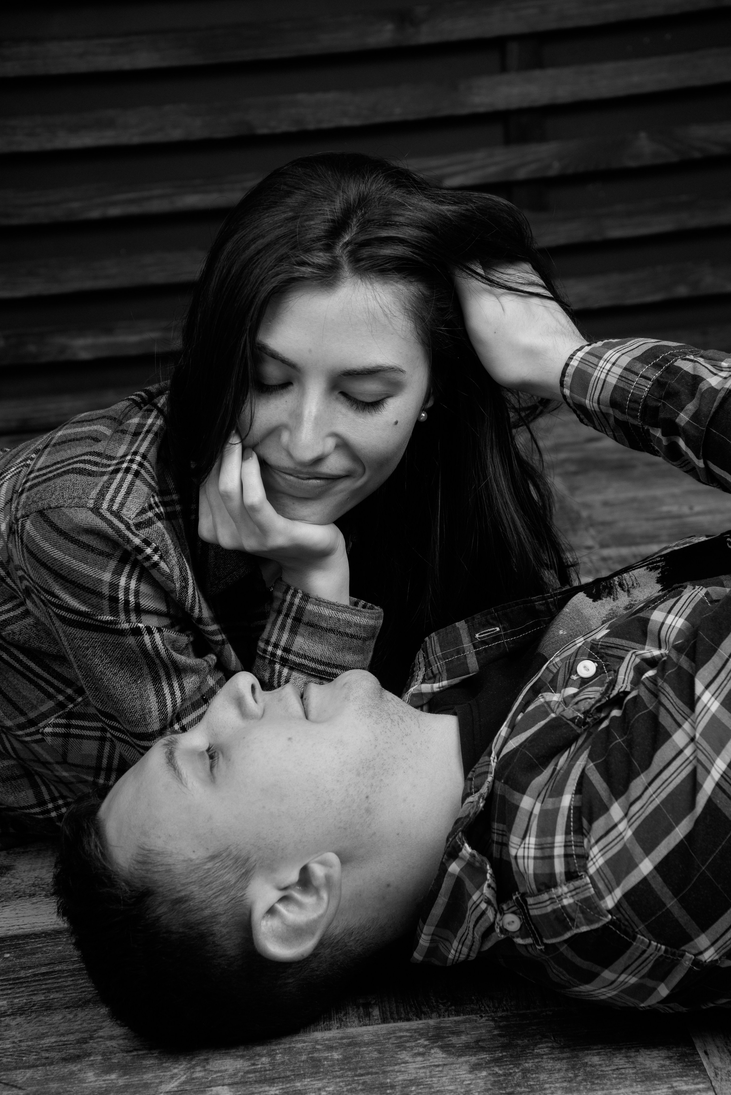 Eine Person hält den Kopf der anderen sanft in den Händen, emotionales und intimes Porträt vor dunklem Hintergrund.