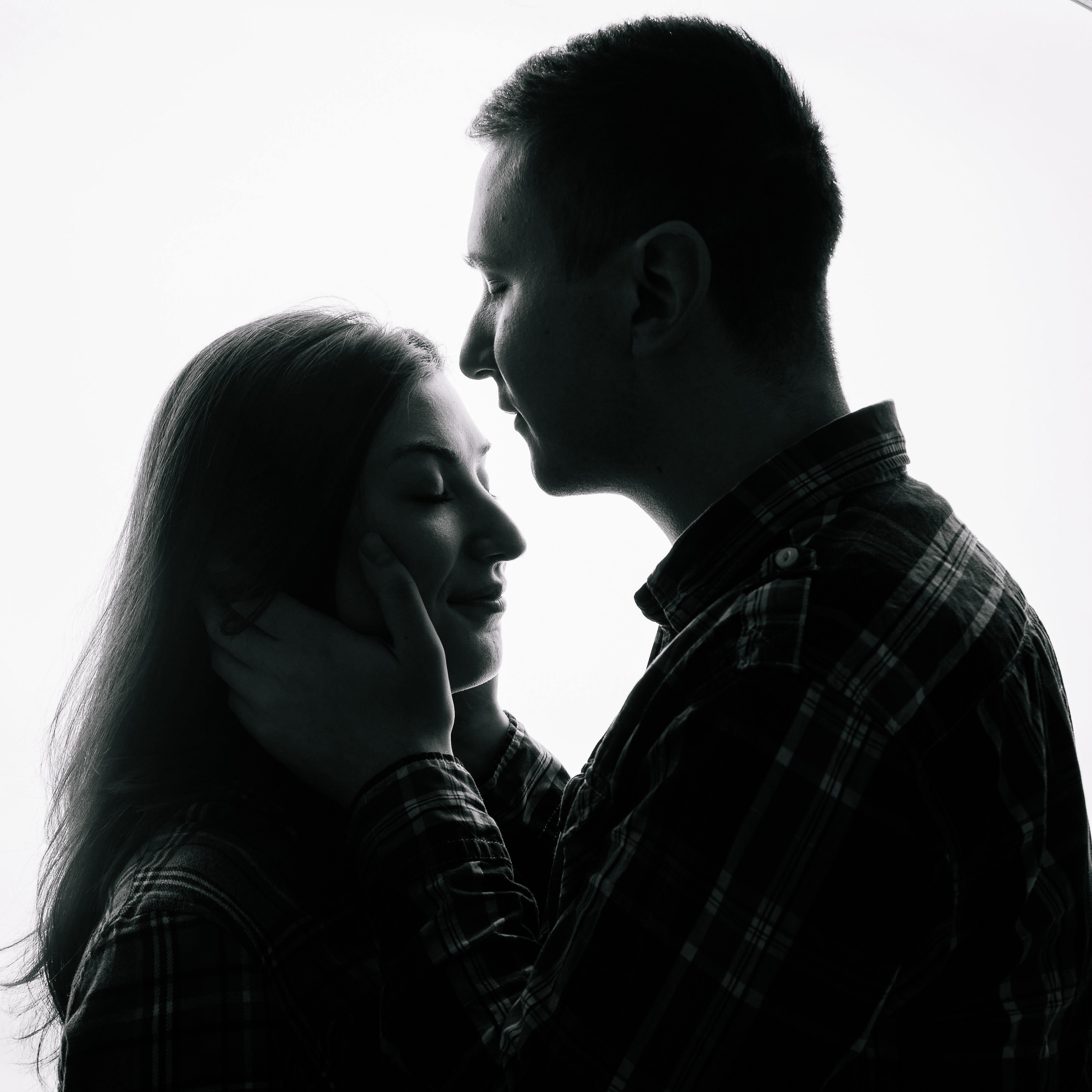 Zwei Personen stehen sich gegenüber im Gegenlicht, Silhouette mit zarter und ruhiger Stimmung.