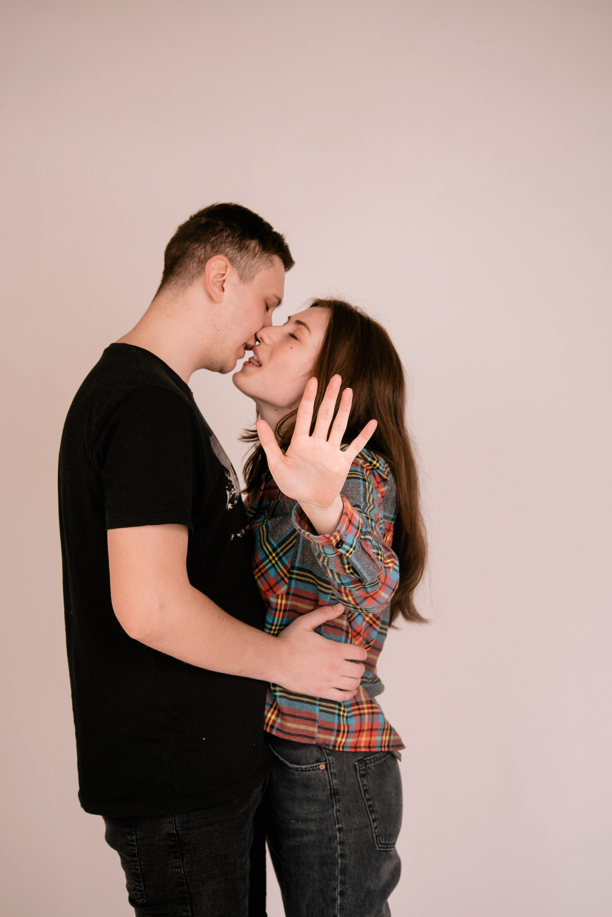Zwei Personen umarmen sich vor dunklem Hintergrund, emotionales und modernes Paarfoto.