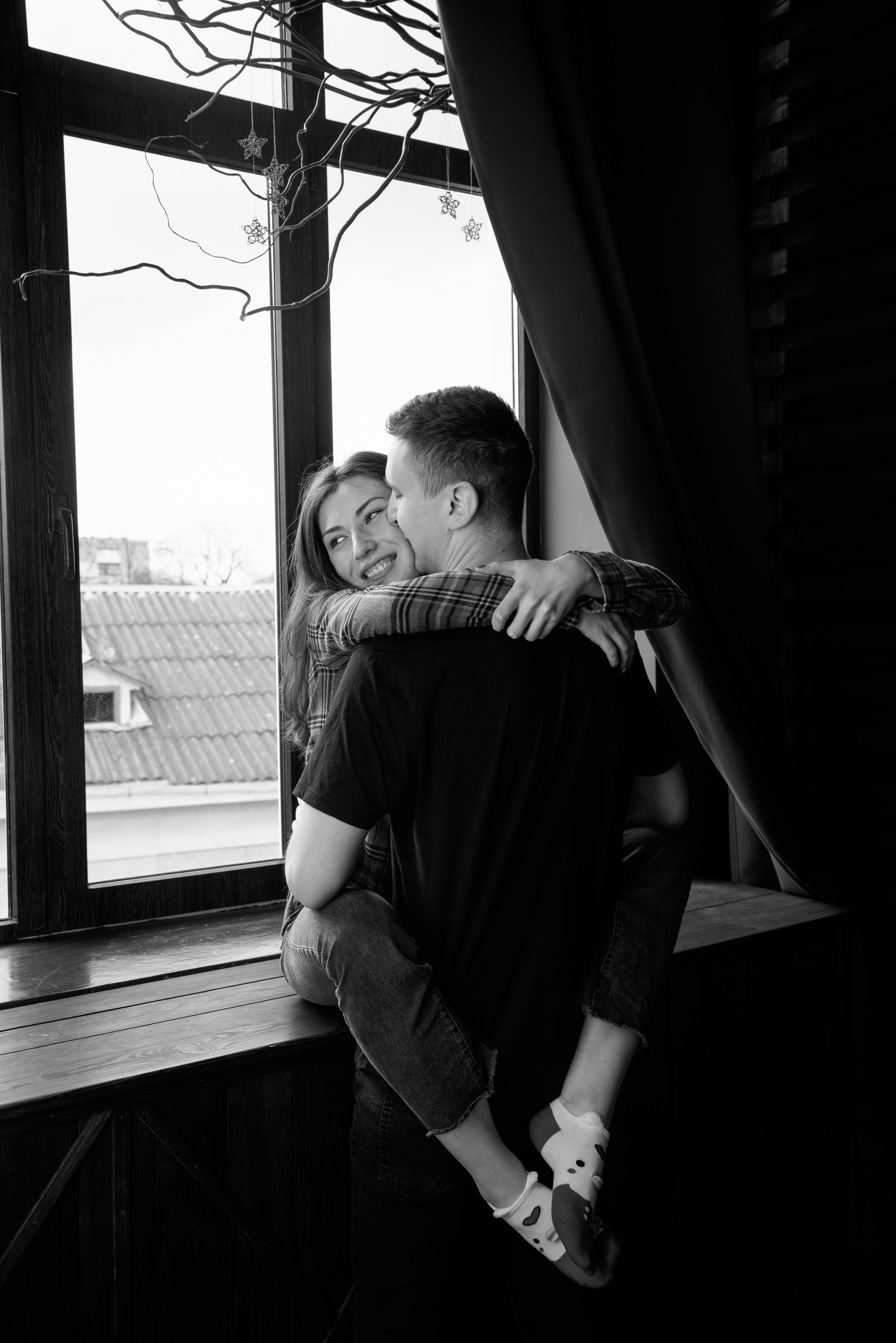 Zwei Personen stehen am Fenster im Gegenlicht, Silhouette mit natürlichem Licht und ruhiger Atmosphäre.