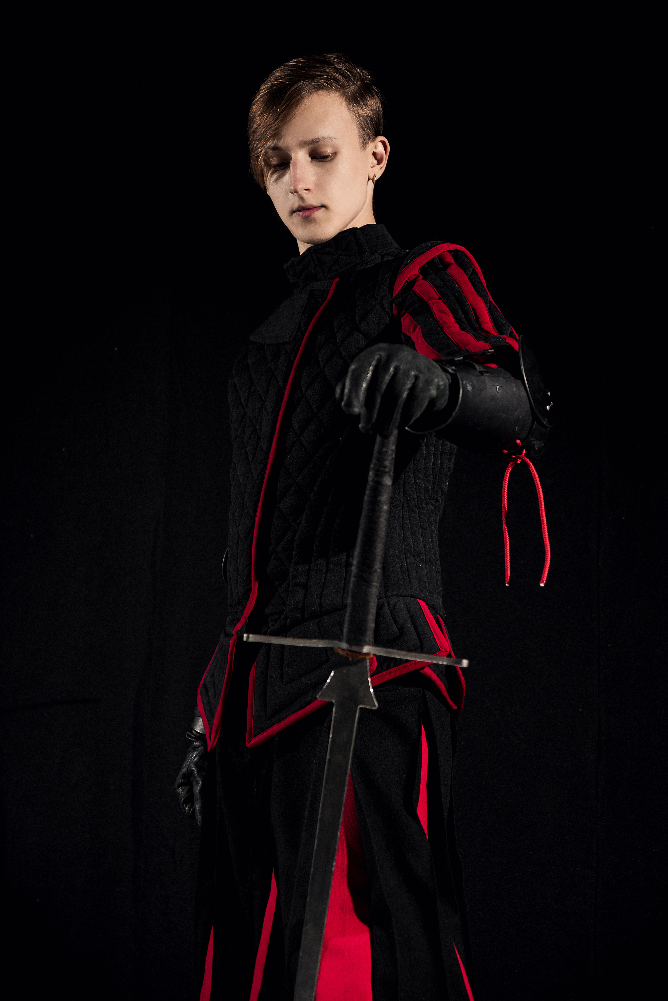 Чоловічий портрет зі зброєю на чорному фоні