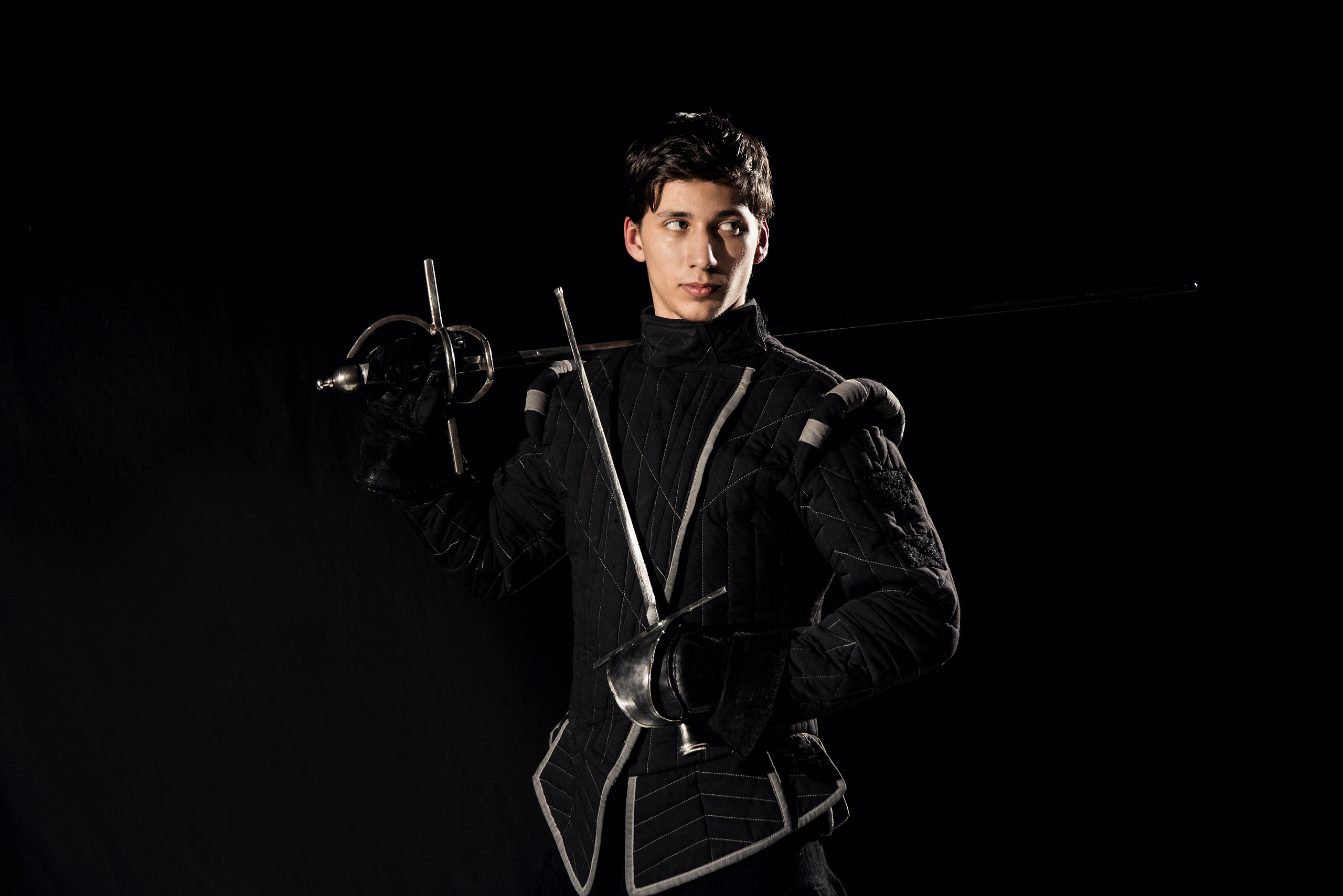 Мужской портрет с оружием в студии в низком ключе 