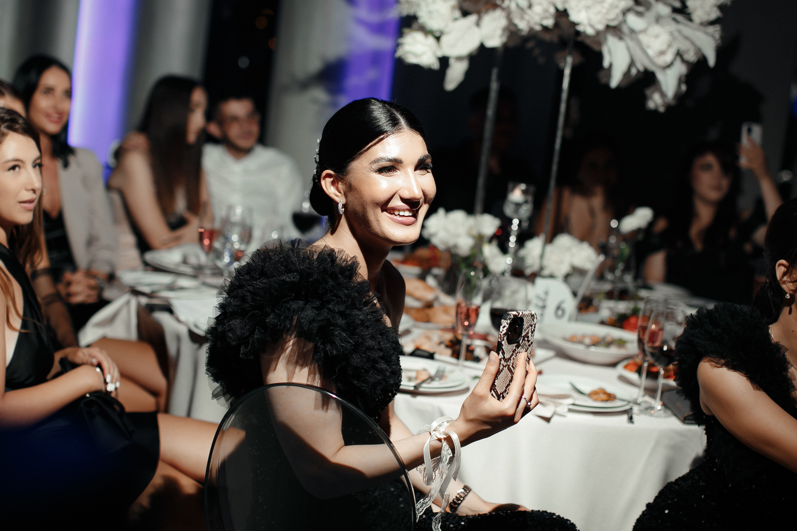 счастливые гости не свадьбе сидят за столом