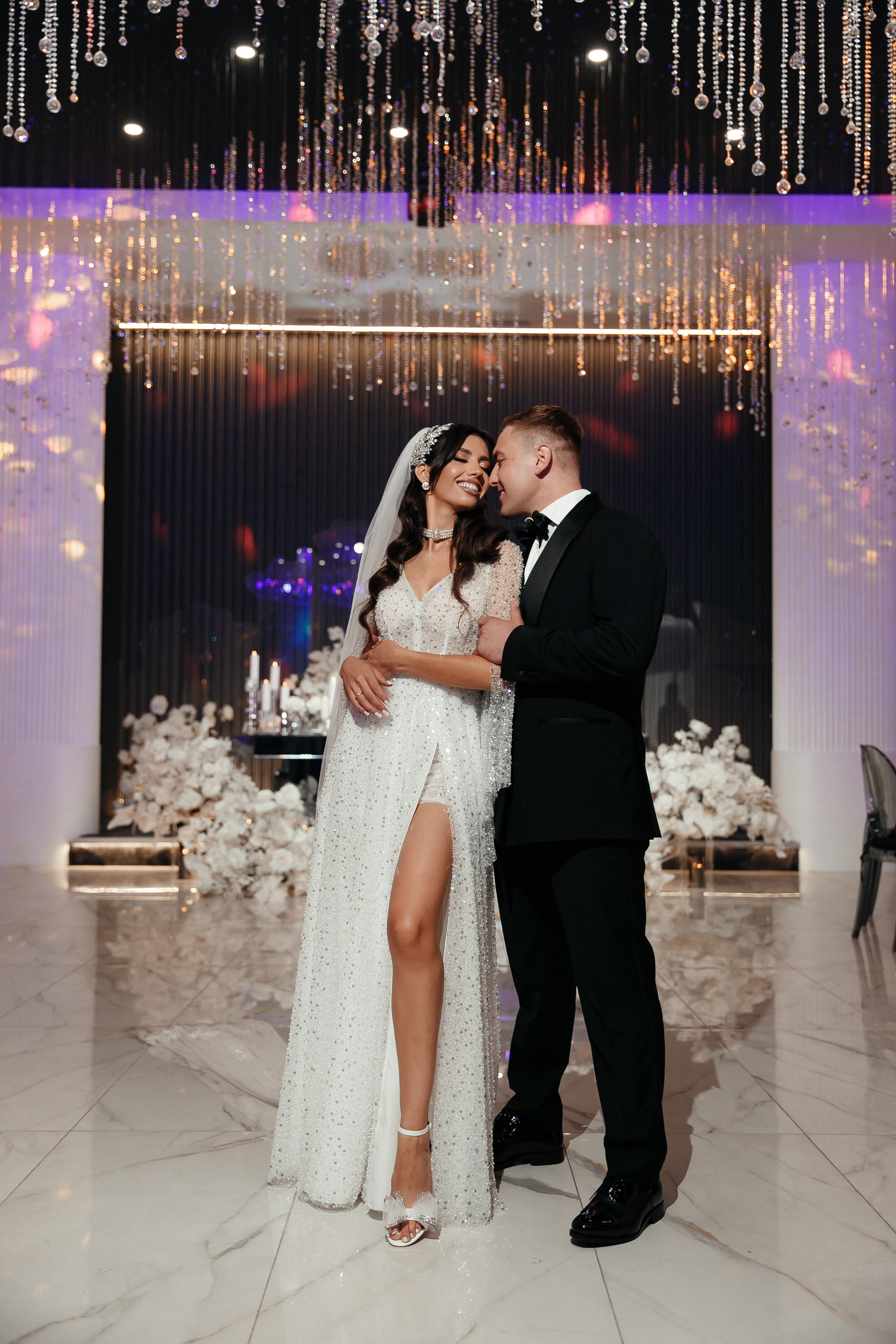 Жених обнимает невесту на фоне президиума Cristal Decor 