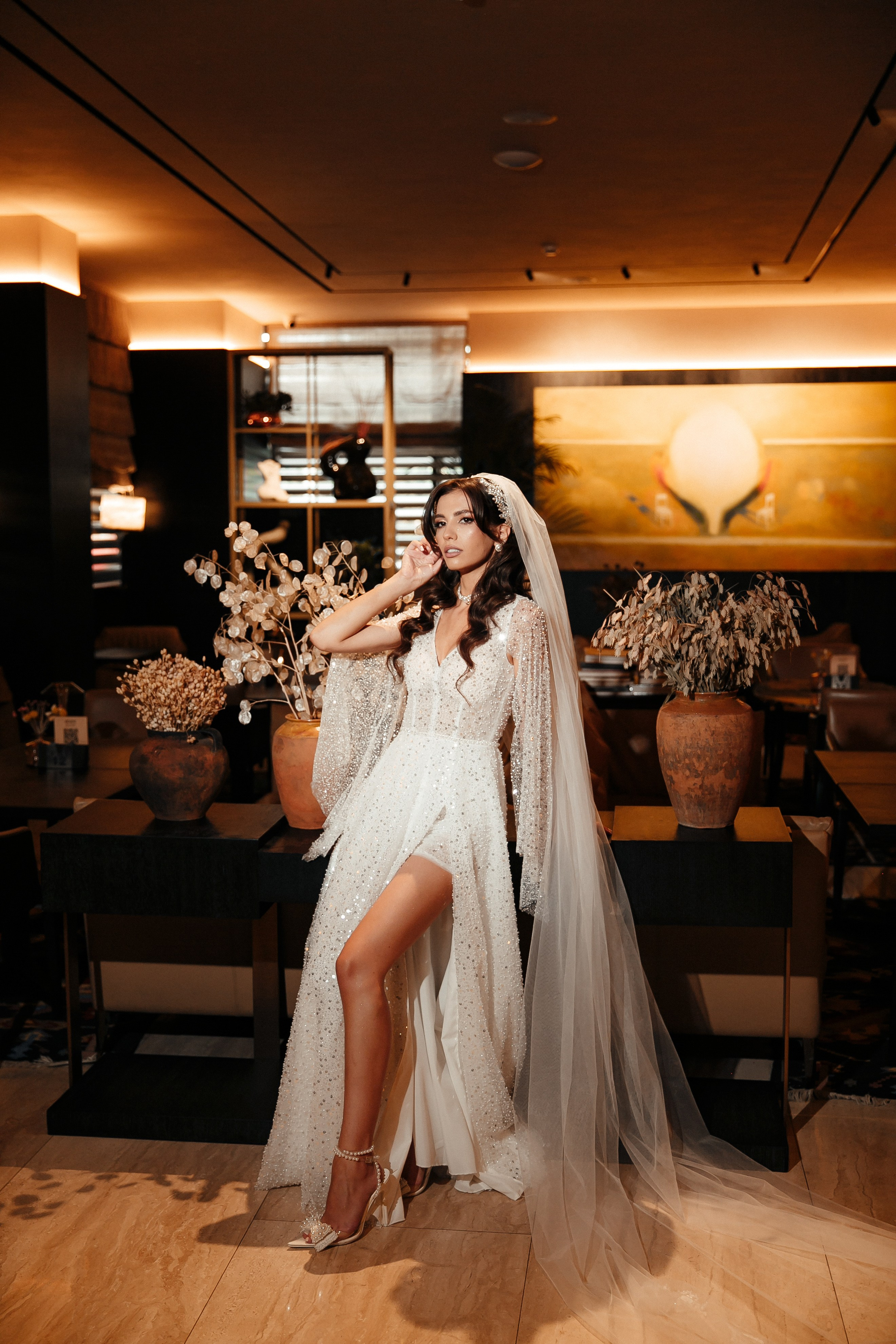 элегантная невеста позирует перед свадебной церемонией