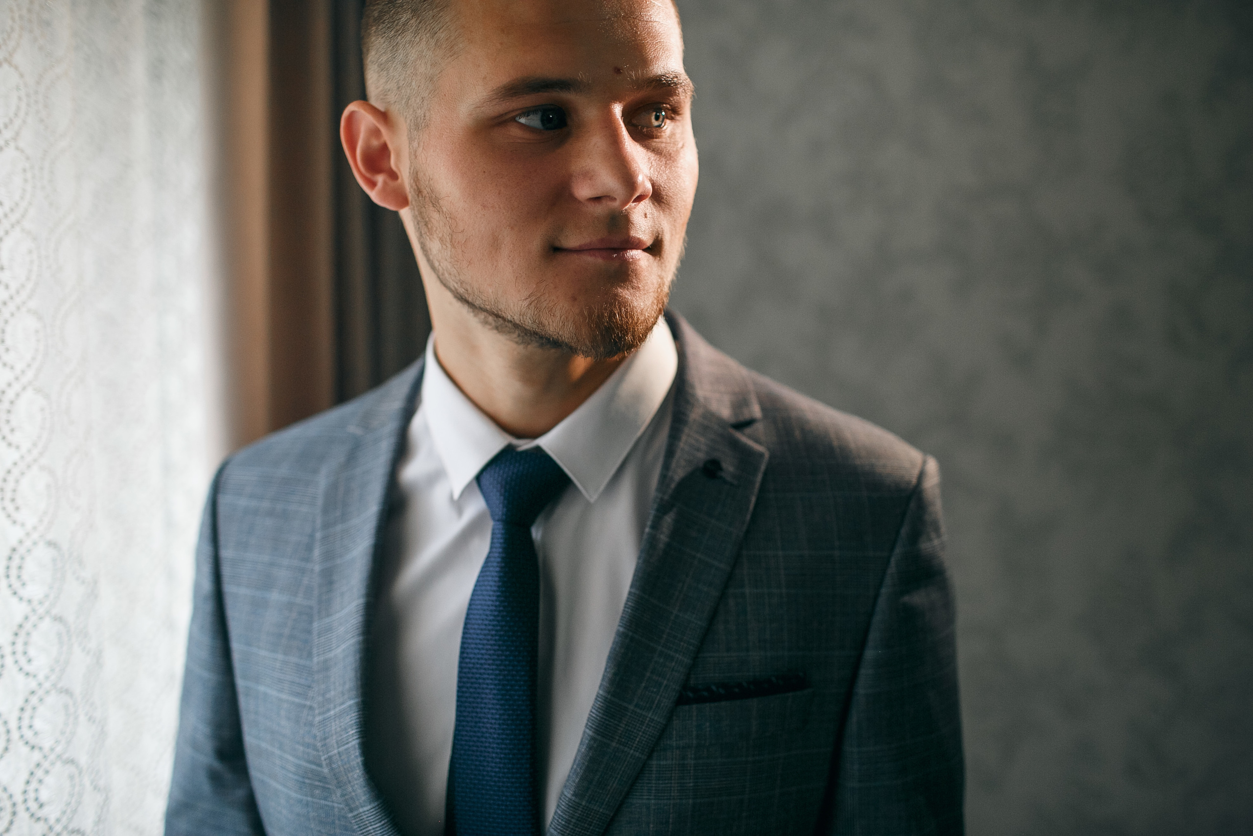 Жених утром стоит у окна и смотрит на невесту 