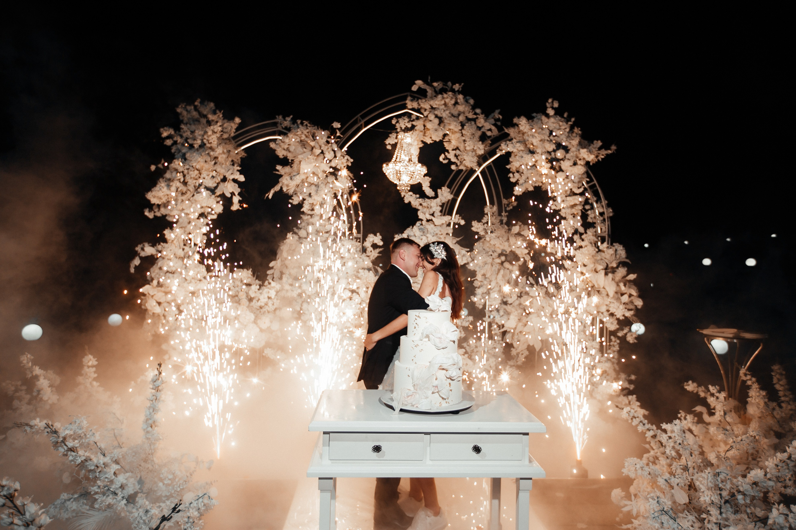 салют во время поцелуя на фоне свадебного торта