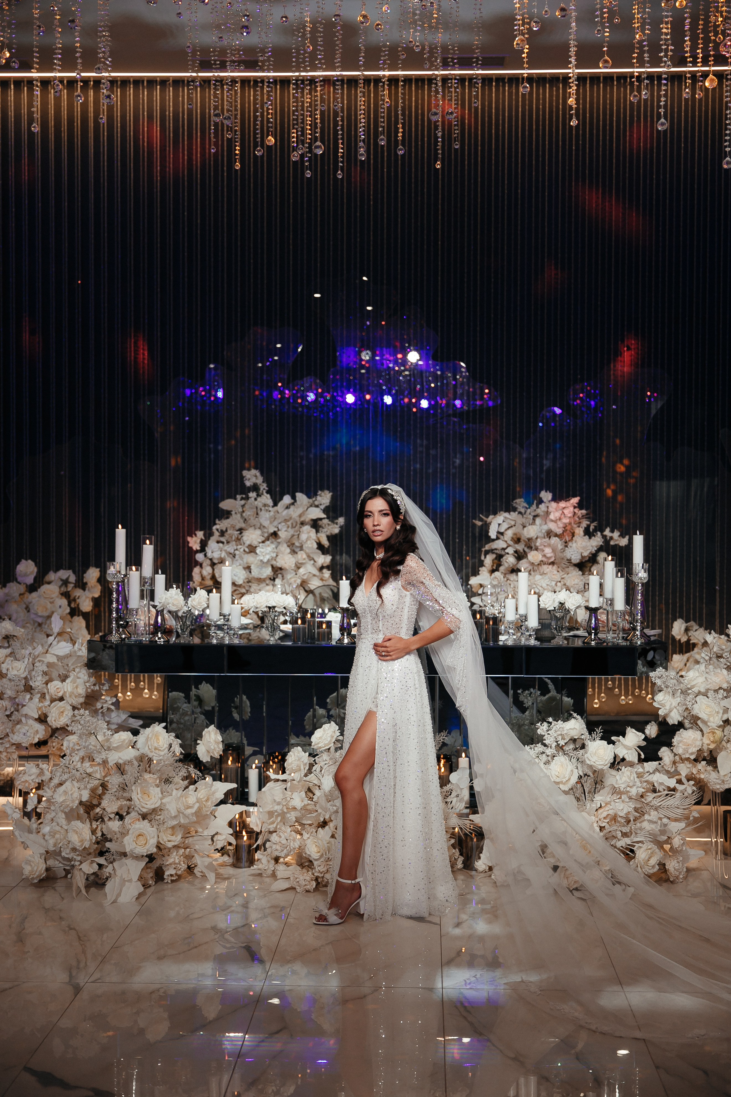 невеста у свадебного стола позирует и смотрит в камеру