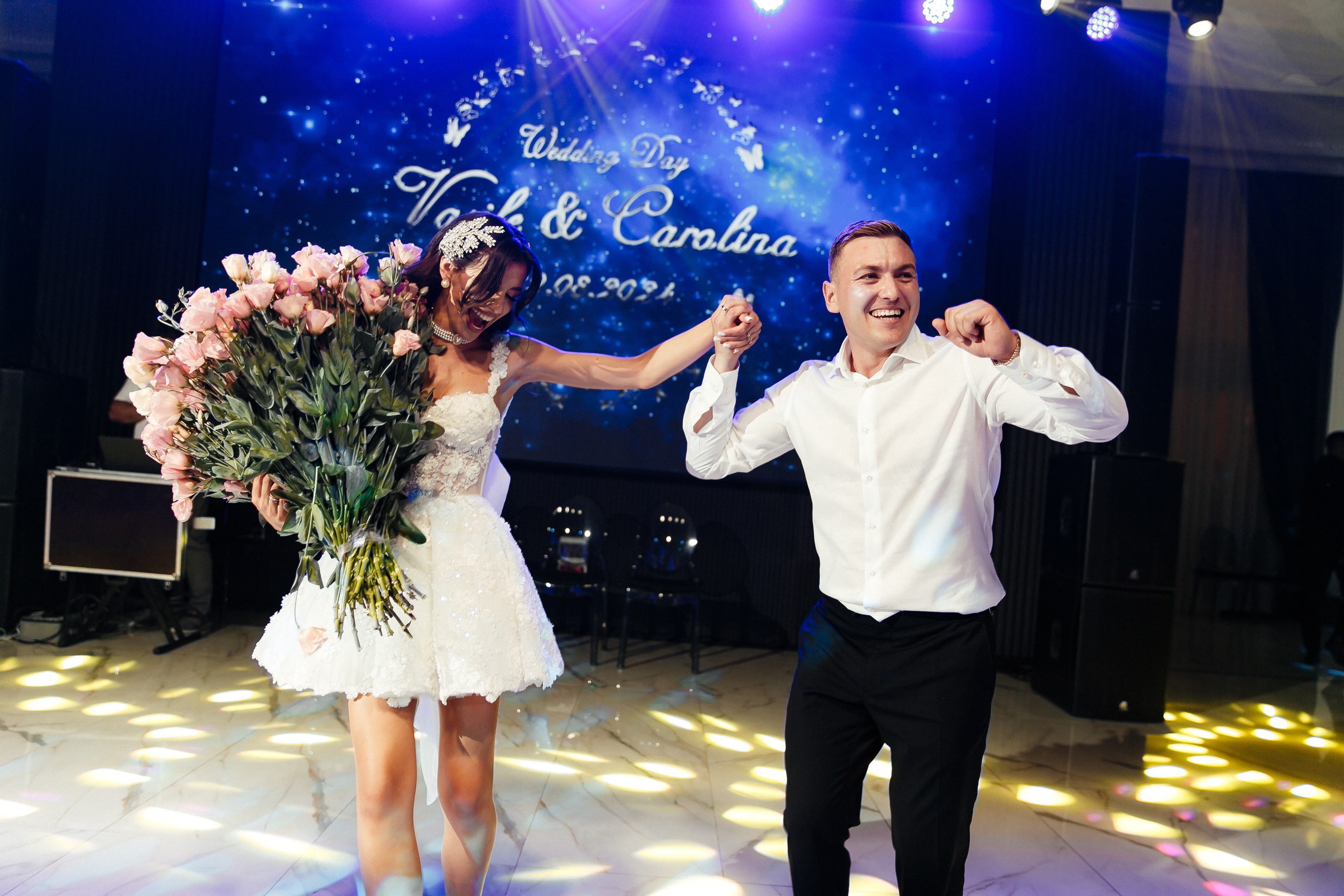 счастливые молодожены танцуют вместе на свадебном банкете