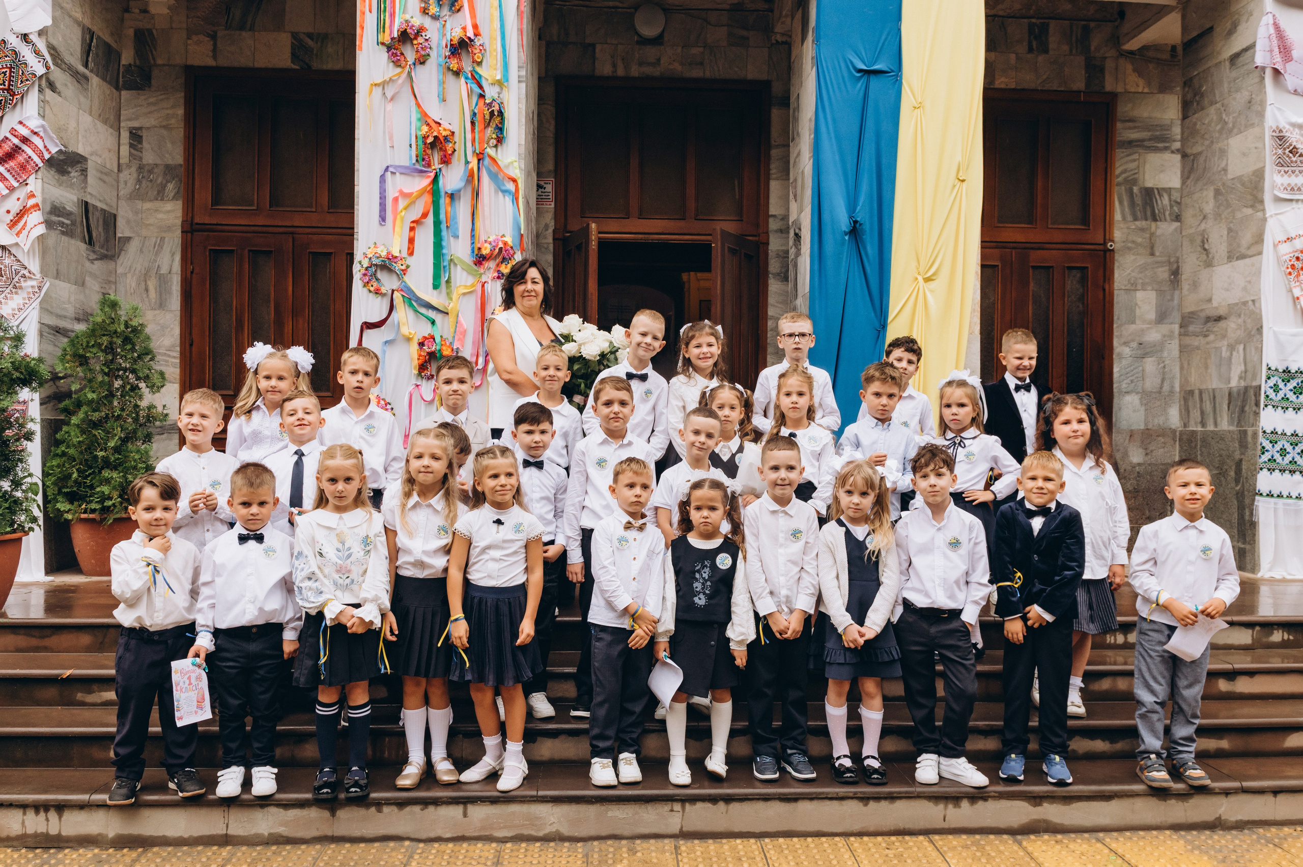 Спільна фотографія першокласників з батьками під час першого шкільного дня.