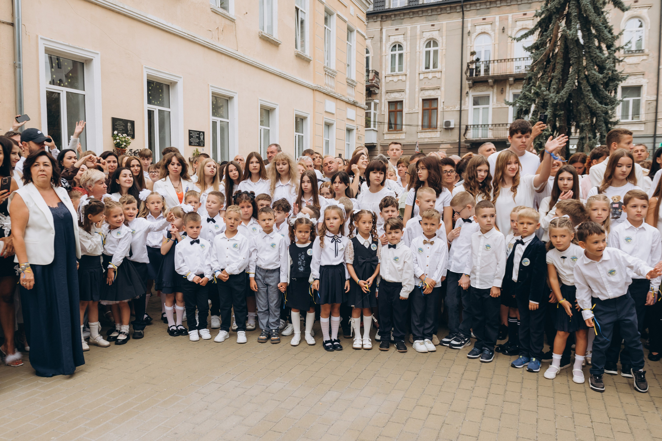 Першокласники слухають урочисту промову під час шкільної лінійки.