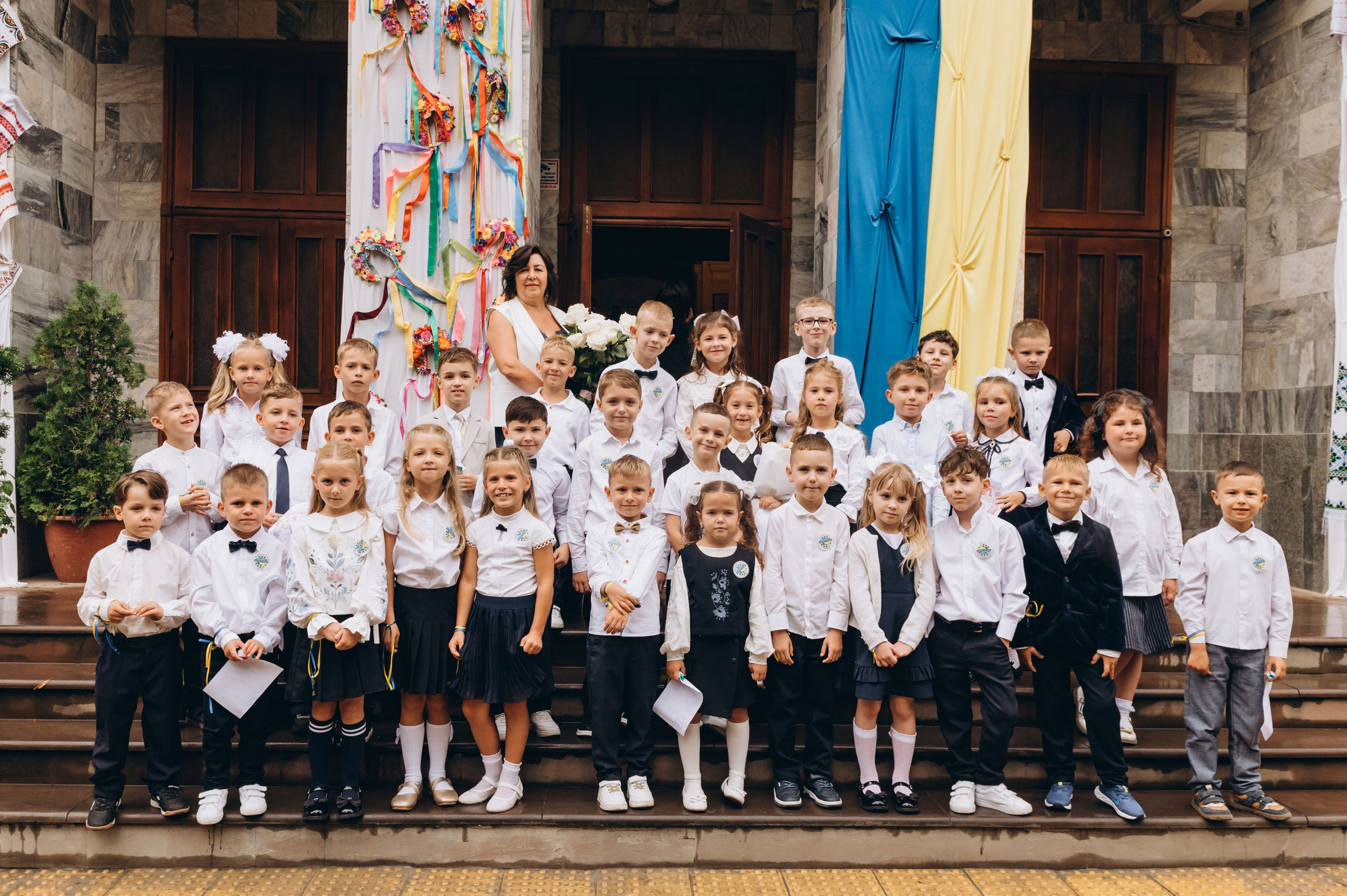 Спільна фотографія першокласників з батьками під час першого шкільного дня.