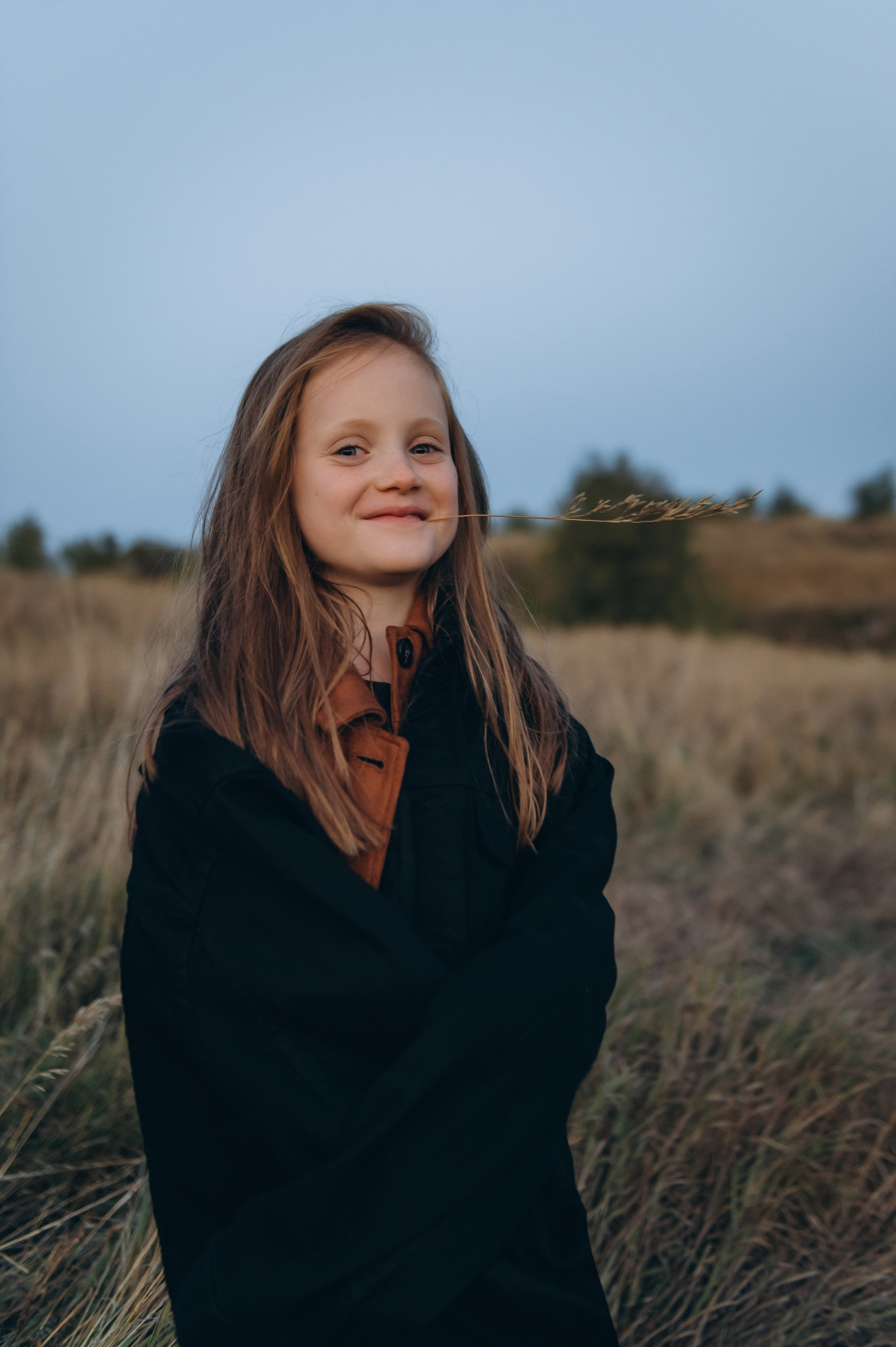 Донька сміється під час сімейної фотосесії на природі