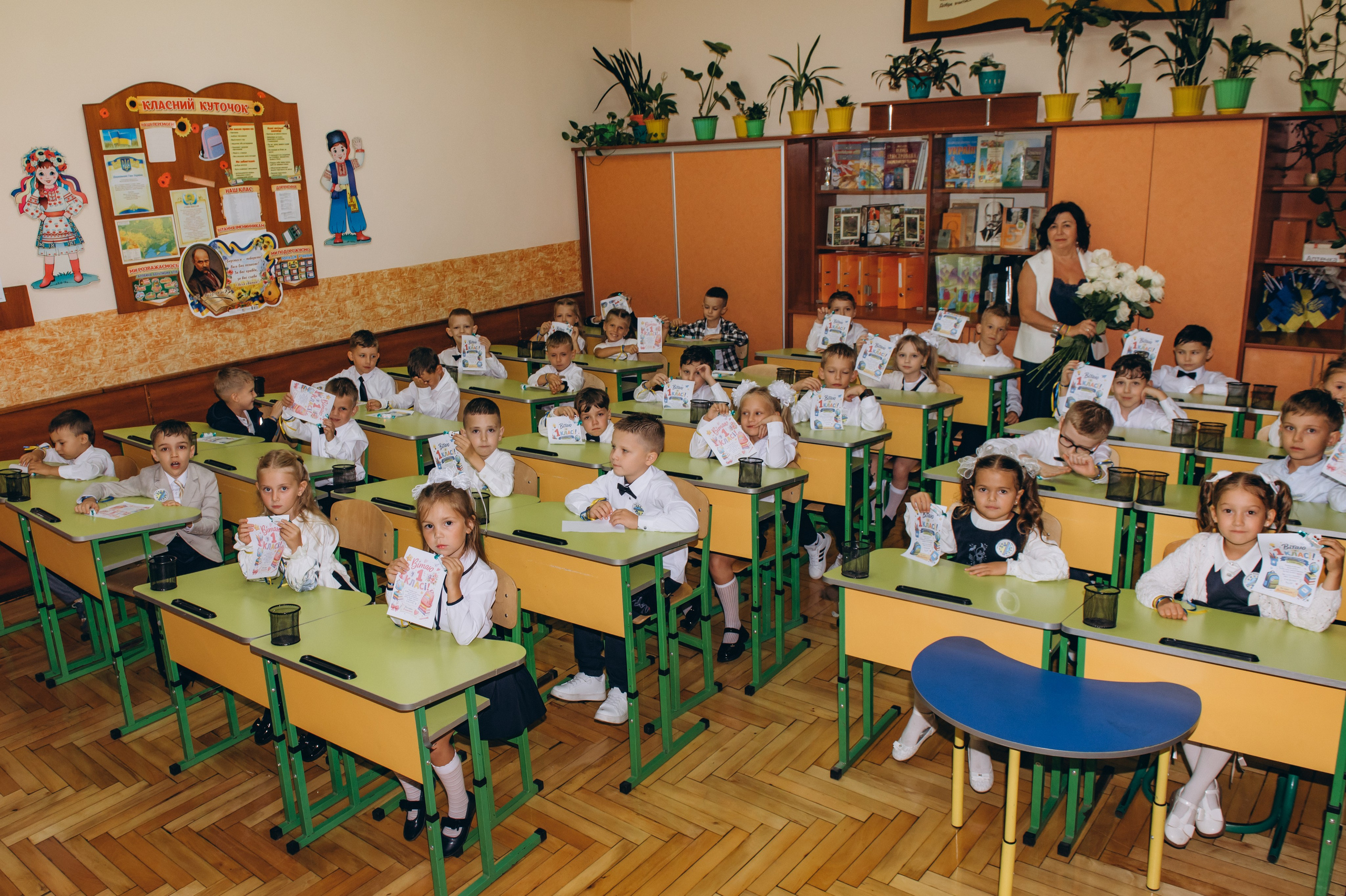 Спільна фотографія учнів 1 класу з учителем у шкільному класі.
