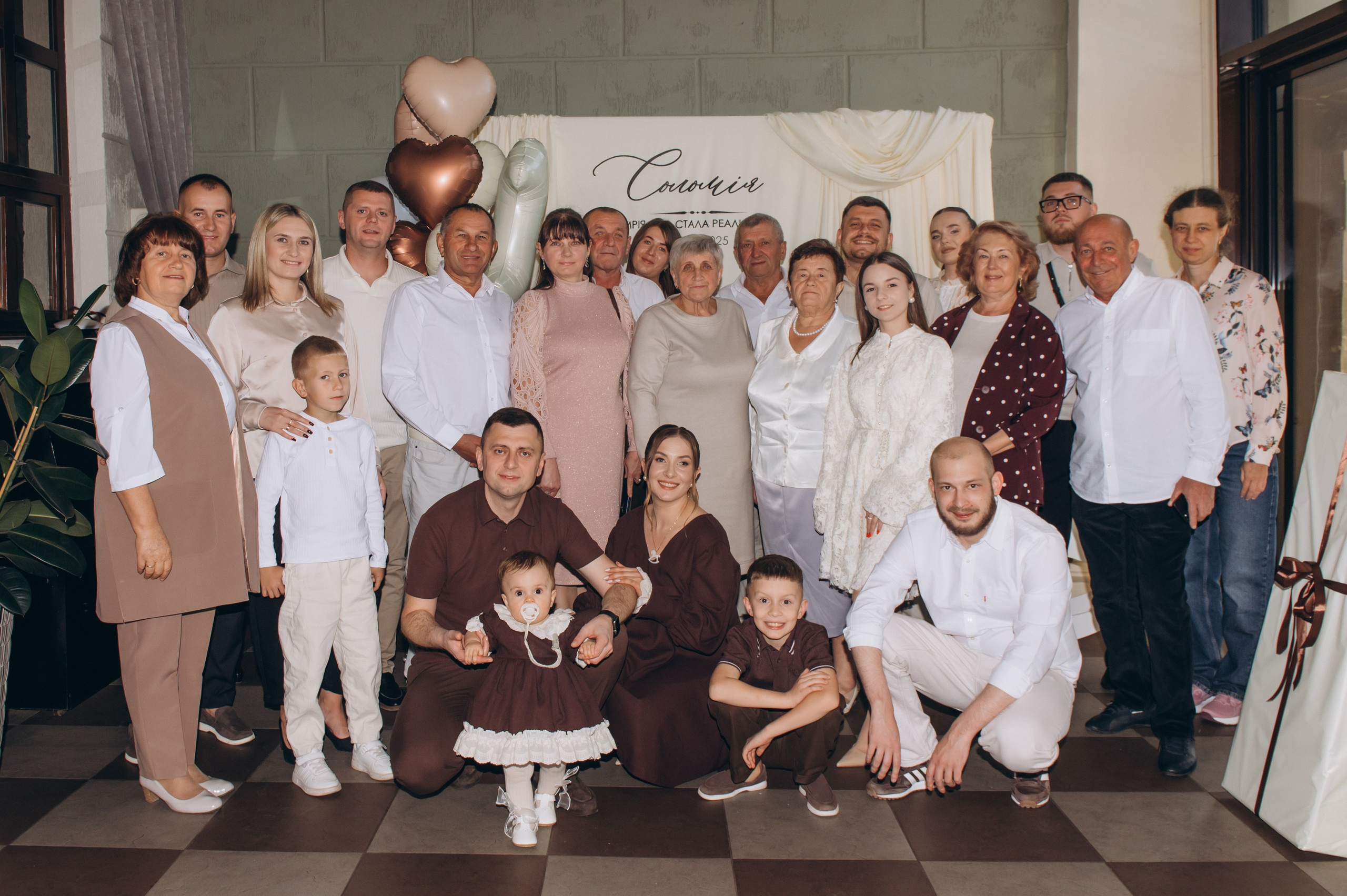 Спільна фотографія родини та гостей на святкуванні першого дня народження.