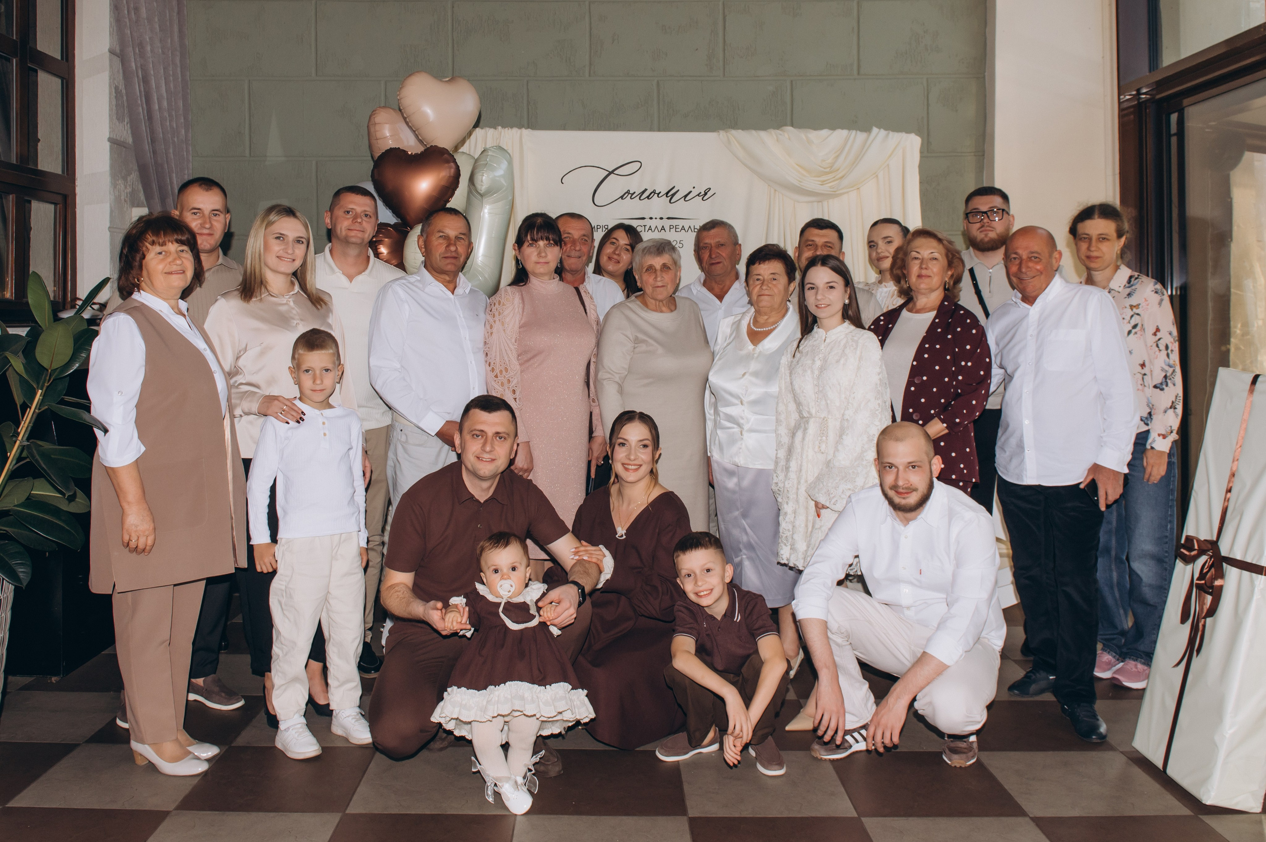 Спільна фотографія родини та гостей на святкуванні першого дня народження.