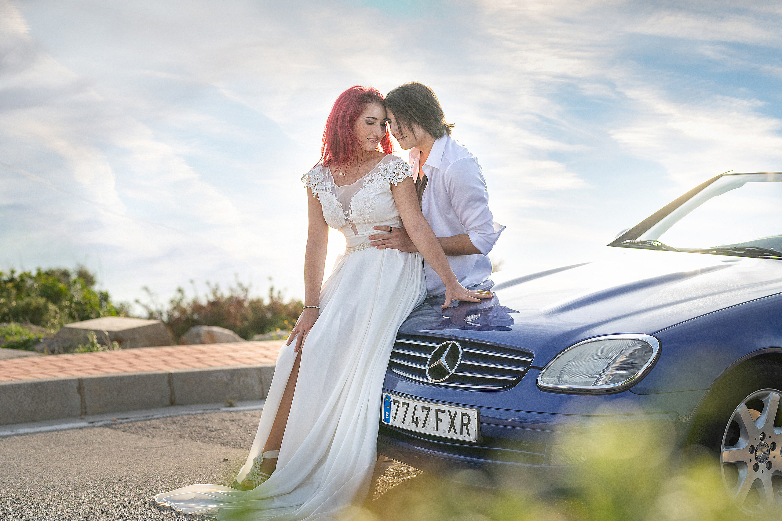 Влюбленная пара у машины на берегу моря